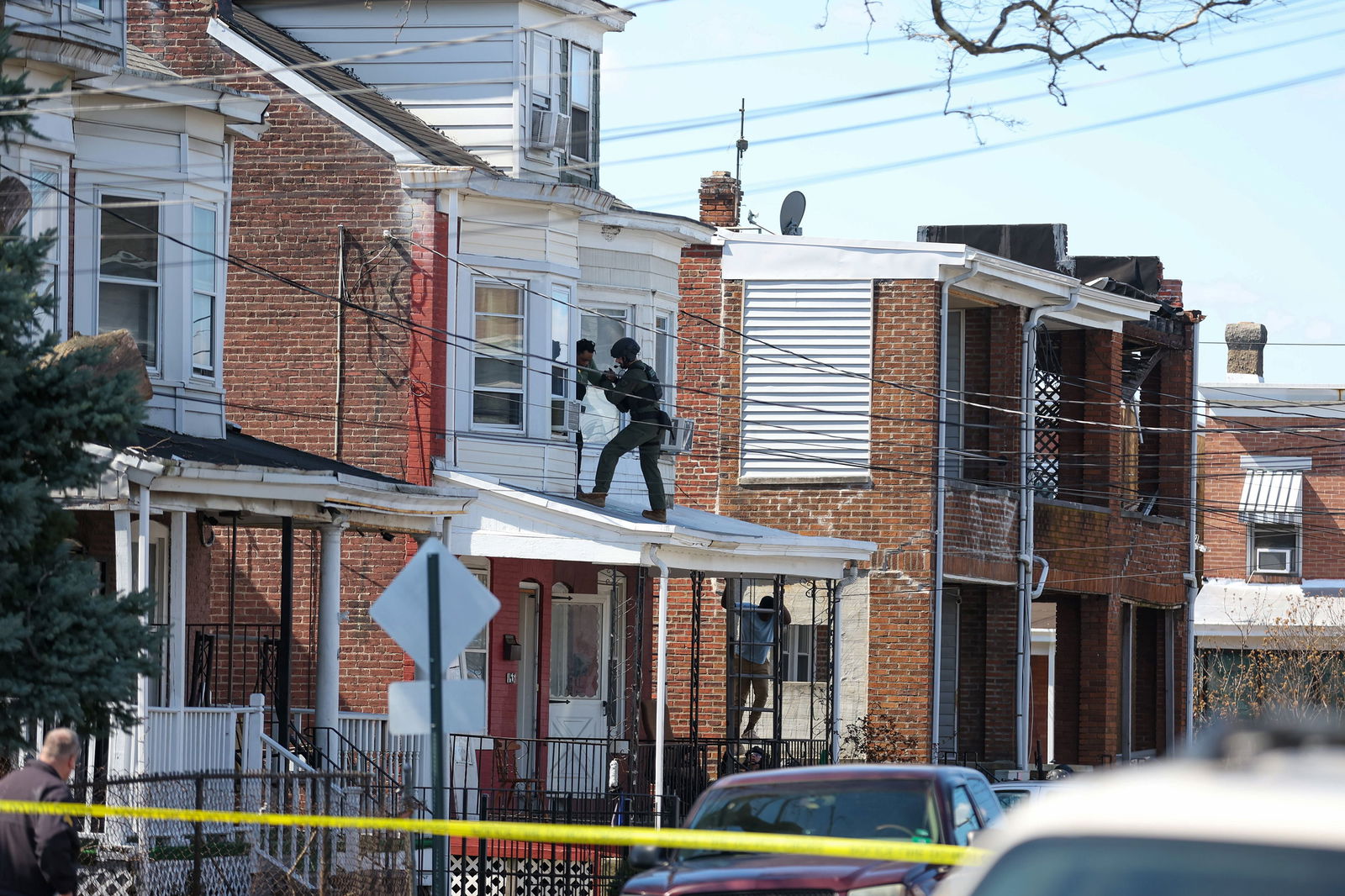 SWAT officers escort people out of a second story window from a residence in Trenton, New Jersey, on Saturday, March 16, 2024. (Tyger Williams/The Philadelphia Inquirer/TNS)