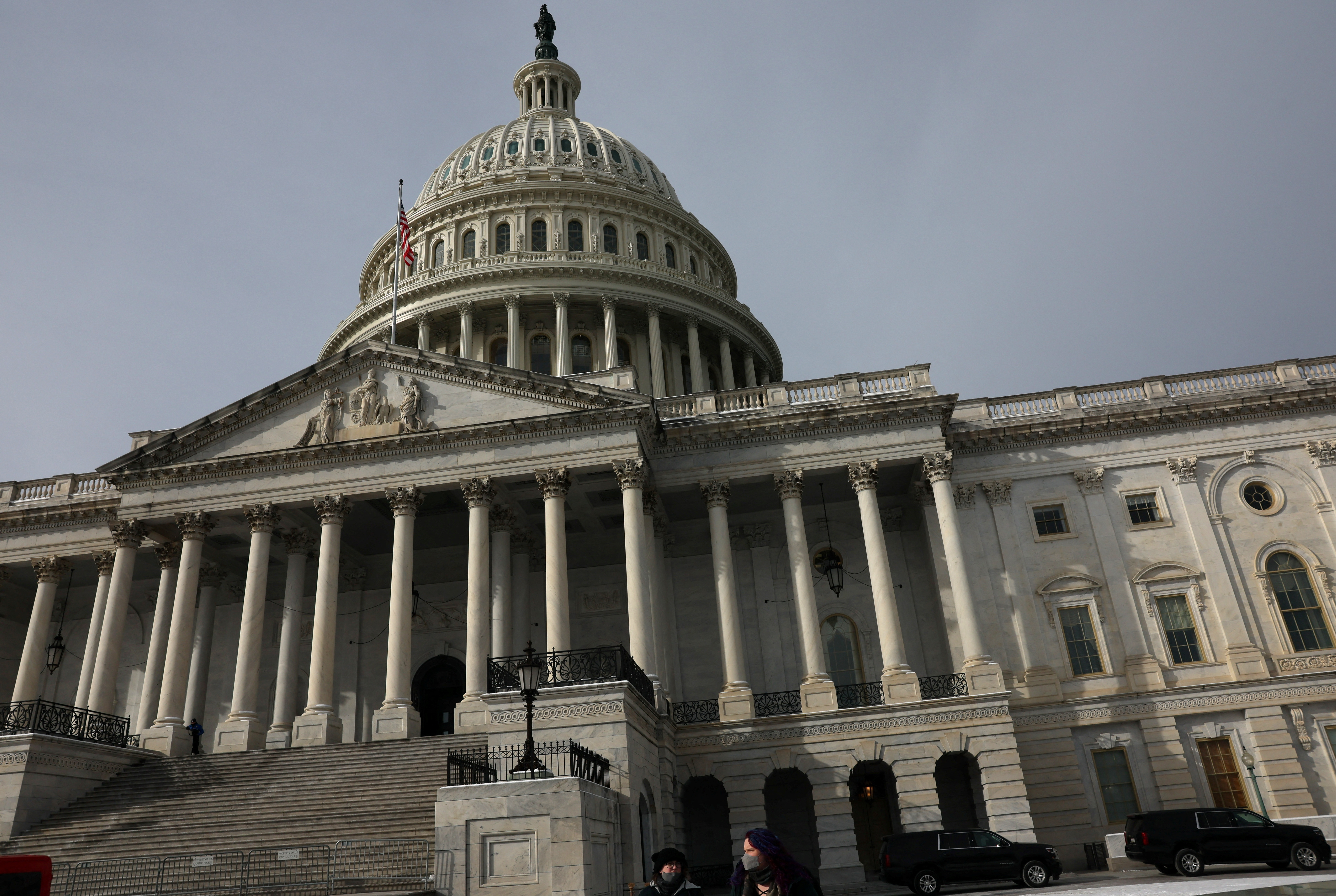 People walk past the U.S. Capitol building as the deadline to avoid partial government shutdown looms in Washington, U.S., January 18, 2024. 