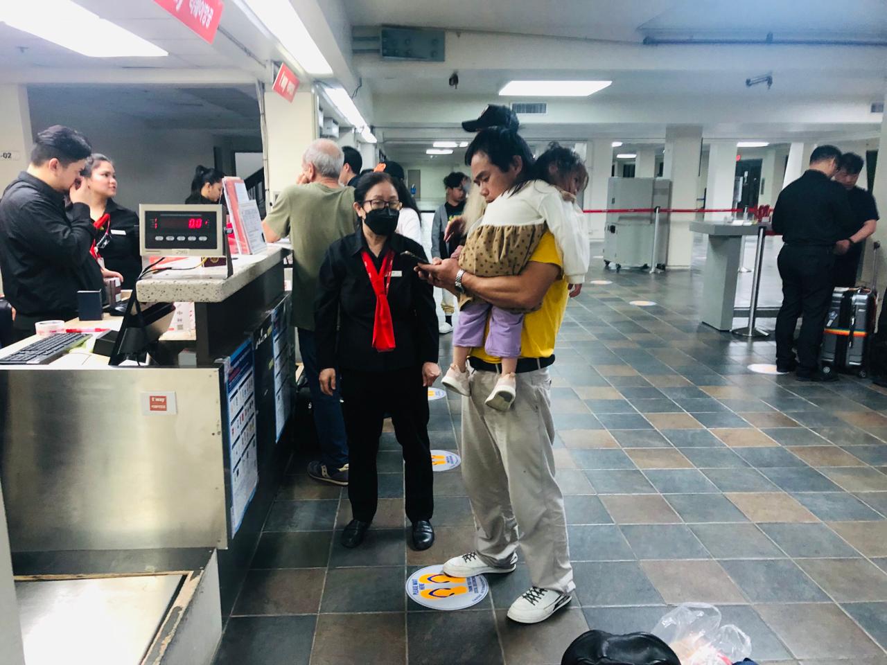 Xu Yuejun and his daughter Ziyu at the T'Way counter to get their boarding passes.