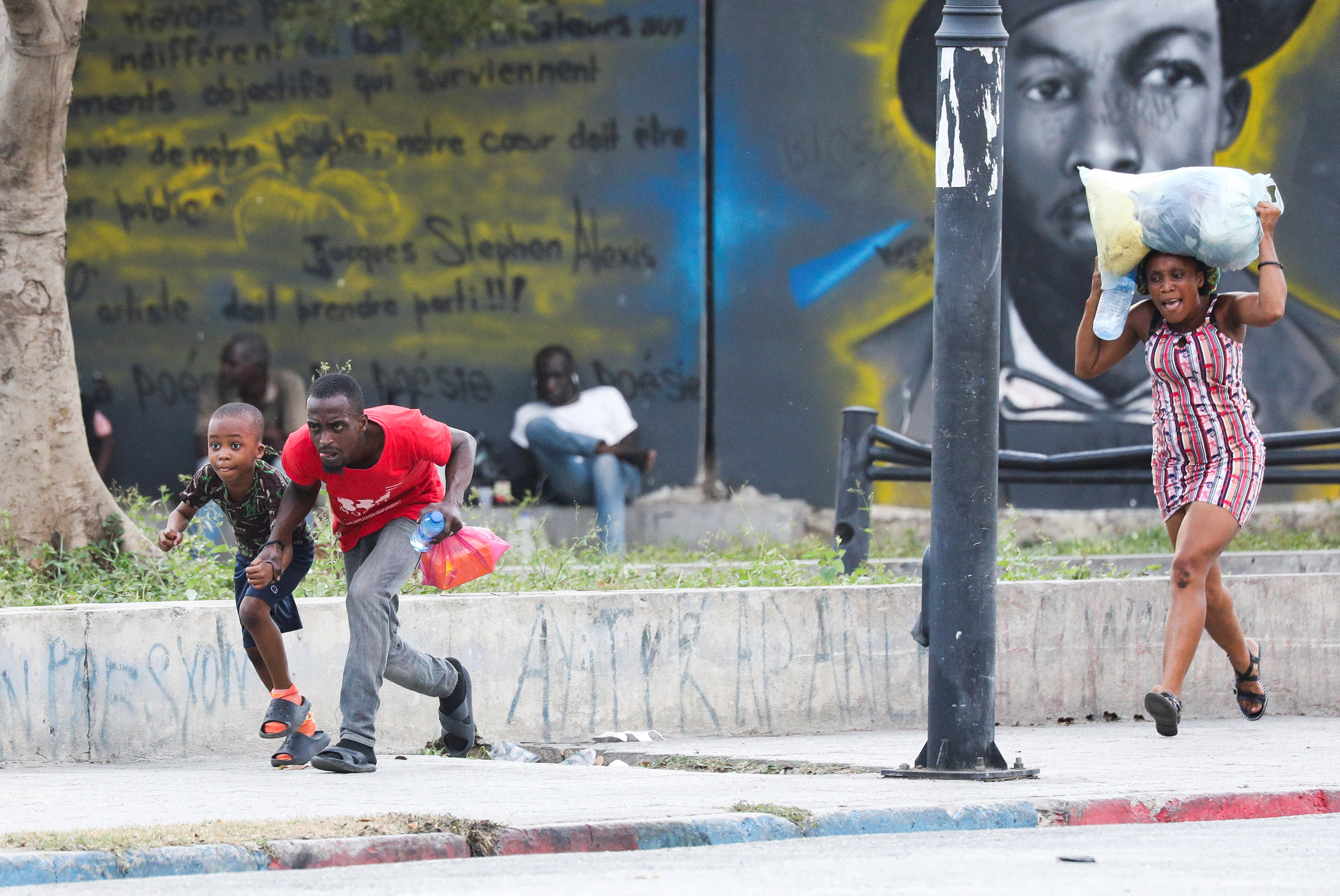 People take cover from gunfire near the National Palace, in Port-au-Prince, Haiti March 21, 2024.