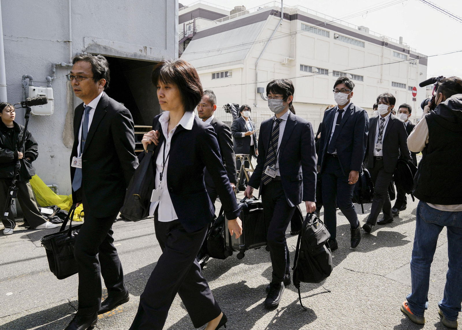 Japanese health ministry officials head to search a Kobayashi Pharmaceutical Co. factory in Osaka, Japan March 30, 2024, in this photo taken by Kyodo. 