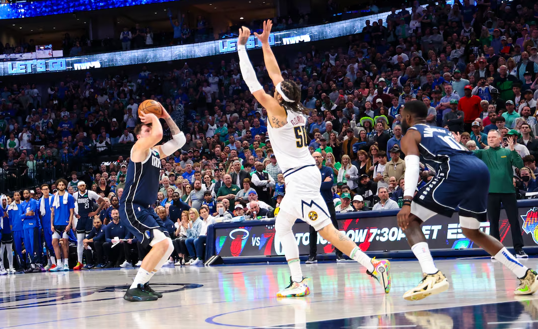 Dallas Mavericks guard Luka Doncic (77) scores a three-point shot over Denver Nuggets forward Aaron Gordon (50) during the second half at American Airlines Center in Dallas, Texas, March 17, 2024.