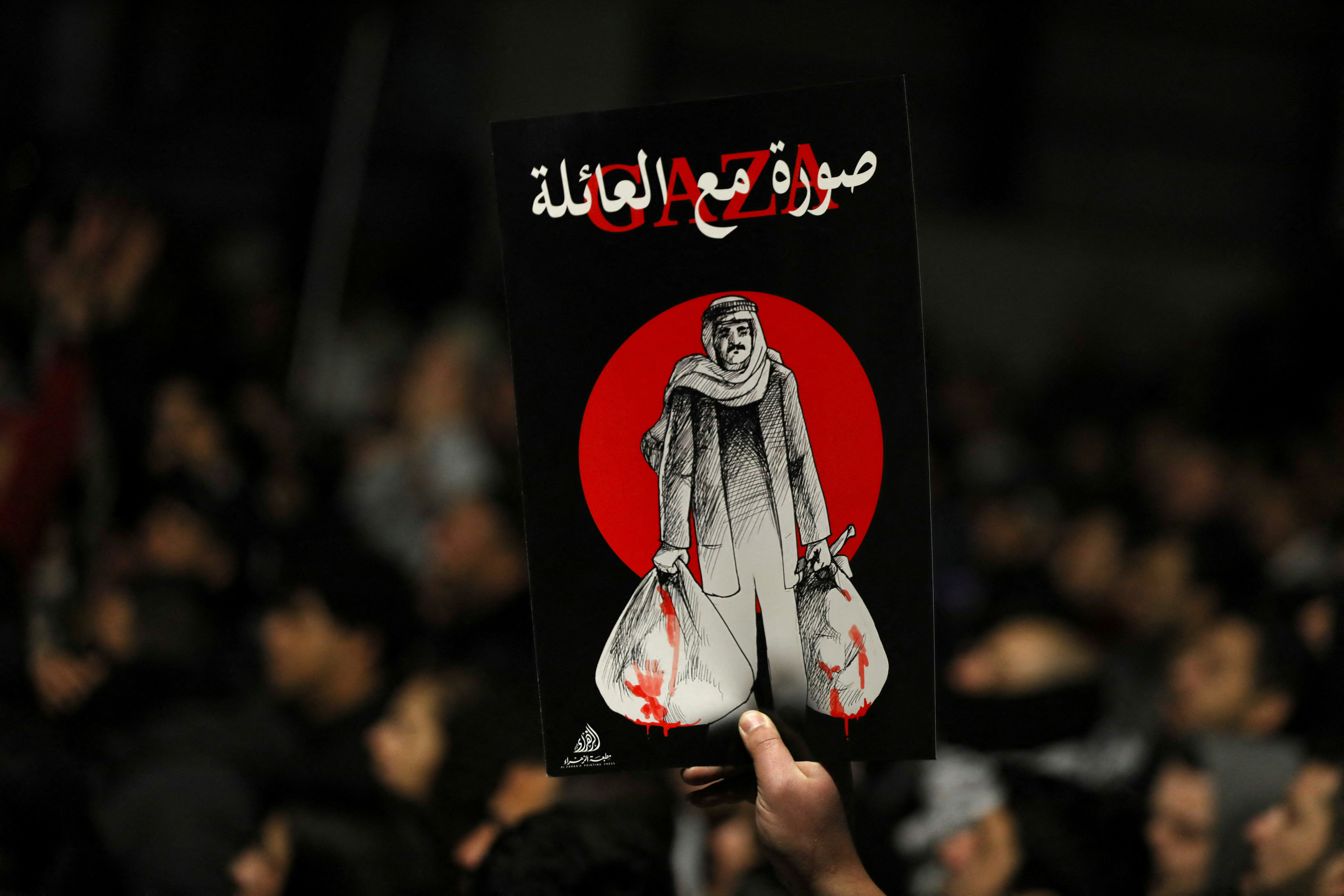 A demonstrator carries a placard during a protest in support of Palestinians in Gaza, amid the ongoing conflict between Israel and the Palestinian Islamist group Hamas, outside Al Kalouti mosque near the Israeli embassy in Amman, Jordan, March 27, 2024. 