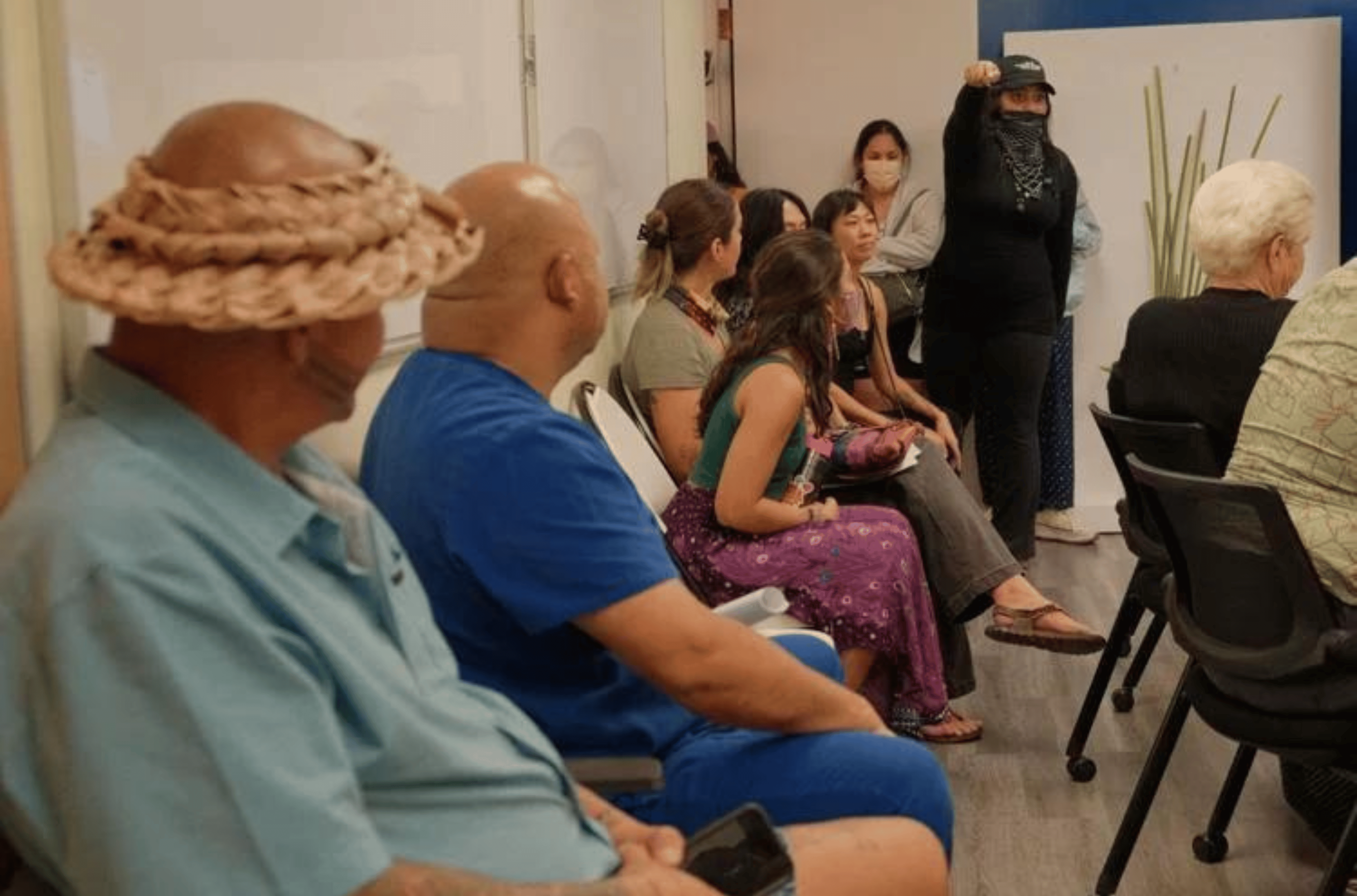 A. Stephen, wearing a black mask, points to Frank "Ko" San Nicolas, wearing a woven hat, discussing her disapproval of sending him to the upcoming Festival of Pacific Arts and Culture during a Guam Council on the Arts and Humanities Agency board meeting in Hagåtña on Tuesday, March 12, 2024. 