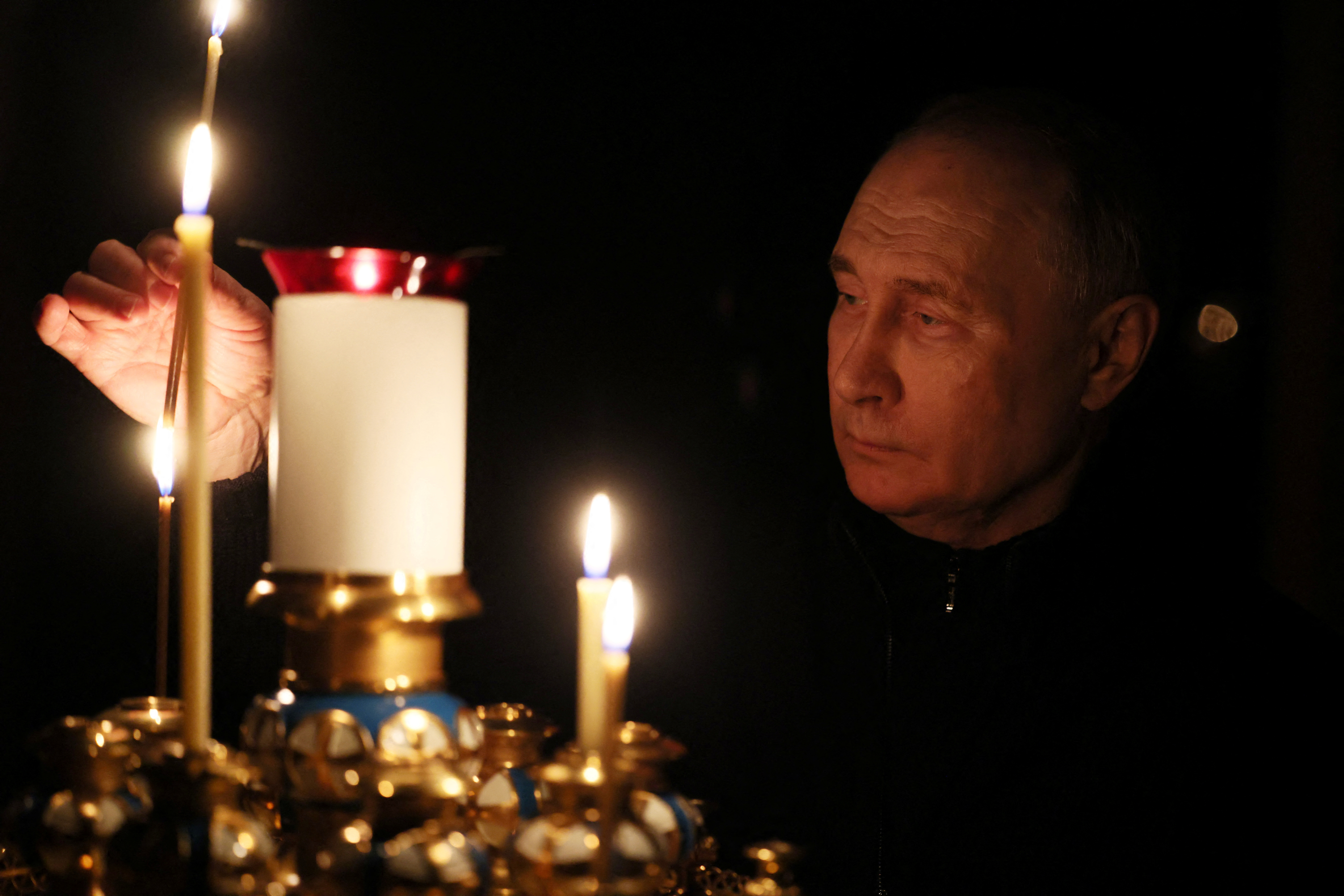 Russian President Vladimir Putin lights a candle in memory of the victims of the Crocus City Hall attack, on the day of national mourning in a church at the Novo-Ogaryovo state residence outside Moscow, Russia March 24, 2024. 
