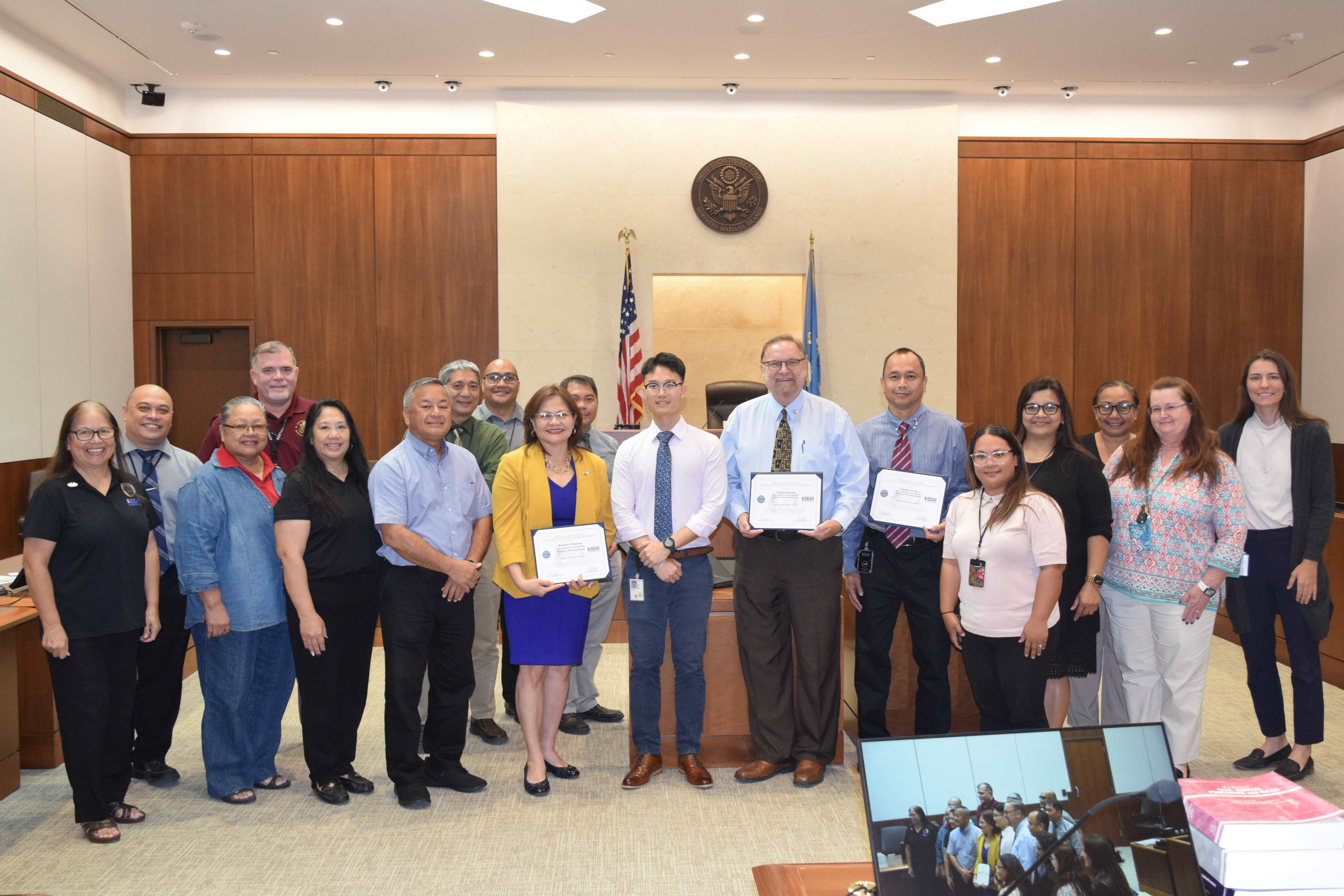 District Court for NMI Chief Judge Ramona V. Manglona, Chief Deputy Clerk William J. Bezzant, Operations Supervisor Timothy V. Wesley and U.S. Air Force Reserve Senior Airman Justin Xu Poo  pose for a photo with other members of the court’s administrative staff and officials of Employer Support for the Guard and Reserve during an awarding ceremony at the federal courthouse on Tuesday. (Not in photo: Magistrate Judge Heather L. Kennedy.)