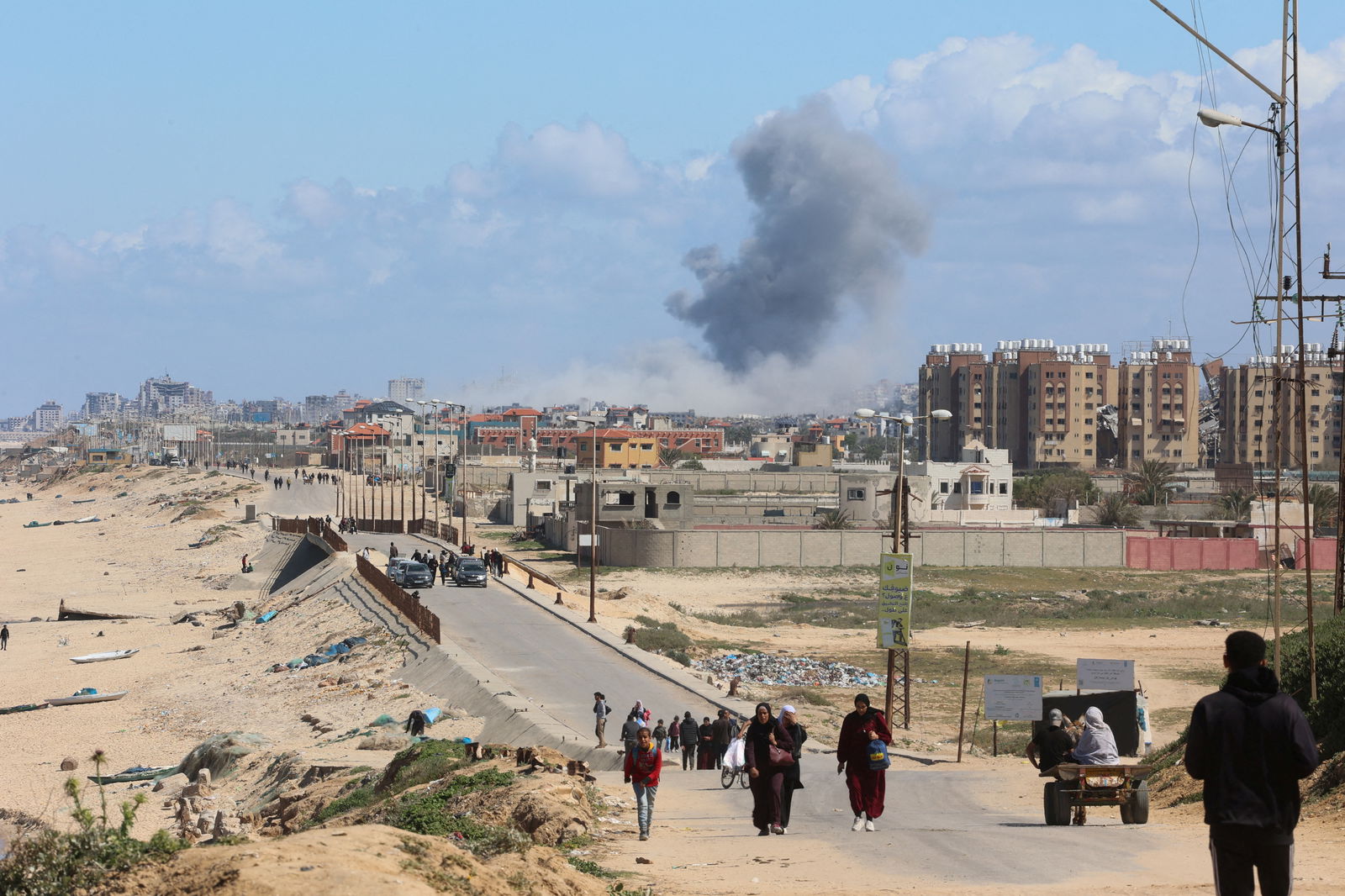 Smoke rises following an Israeli strike as Palestinians fleeing north Gaza due to Israel’s military offensive move southward, amid the ongoing conflict between Israel and Hamas, at the central Gaza Strip, March 15, 2024. 