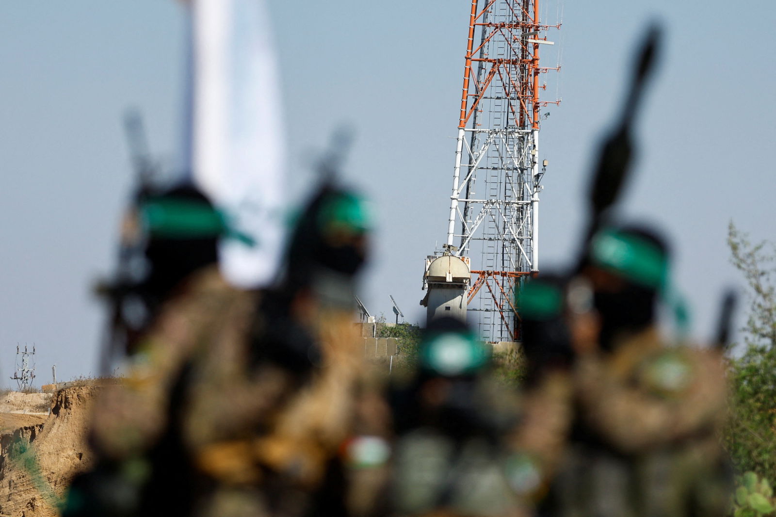 Palestinian fighters from the armed wing of Hamas take part in a military parade in front of an Israeli military site to mark the anniversary of the 2014 war with Israel, near the border in the central Gaza Strip, July 19, 2023. 