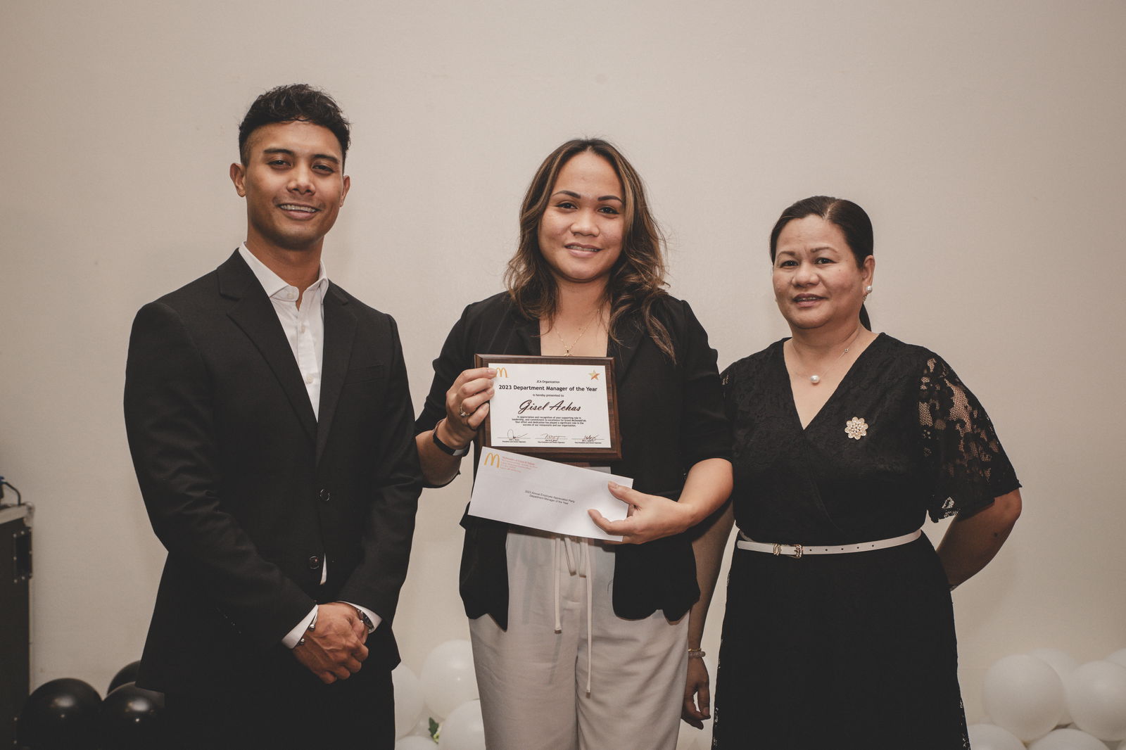 Joe Ayuyu Jr and  Joyce Asistores awards Gisel Achas as Department Manager of the Year.