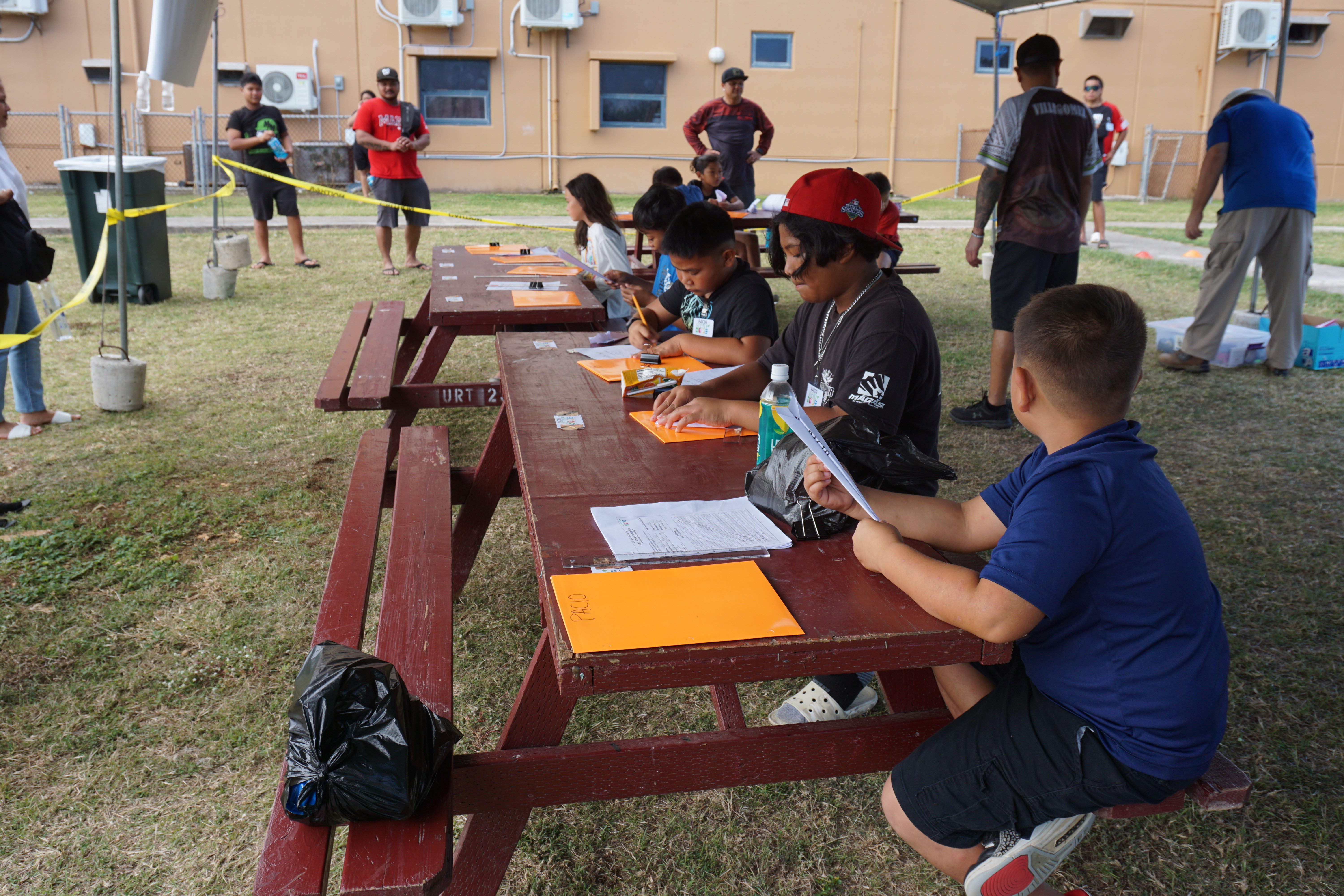 Students fold paper airplanes prior to launching them during the paper airplane competition.