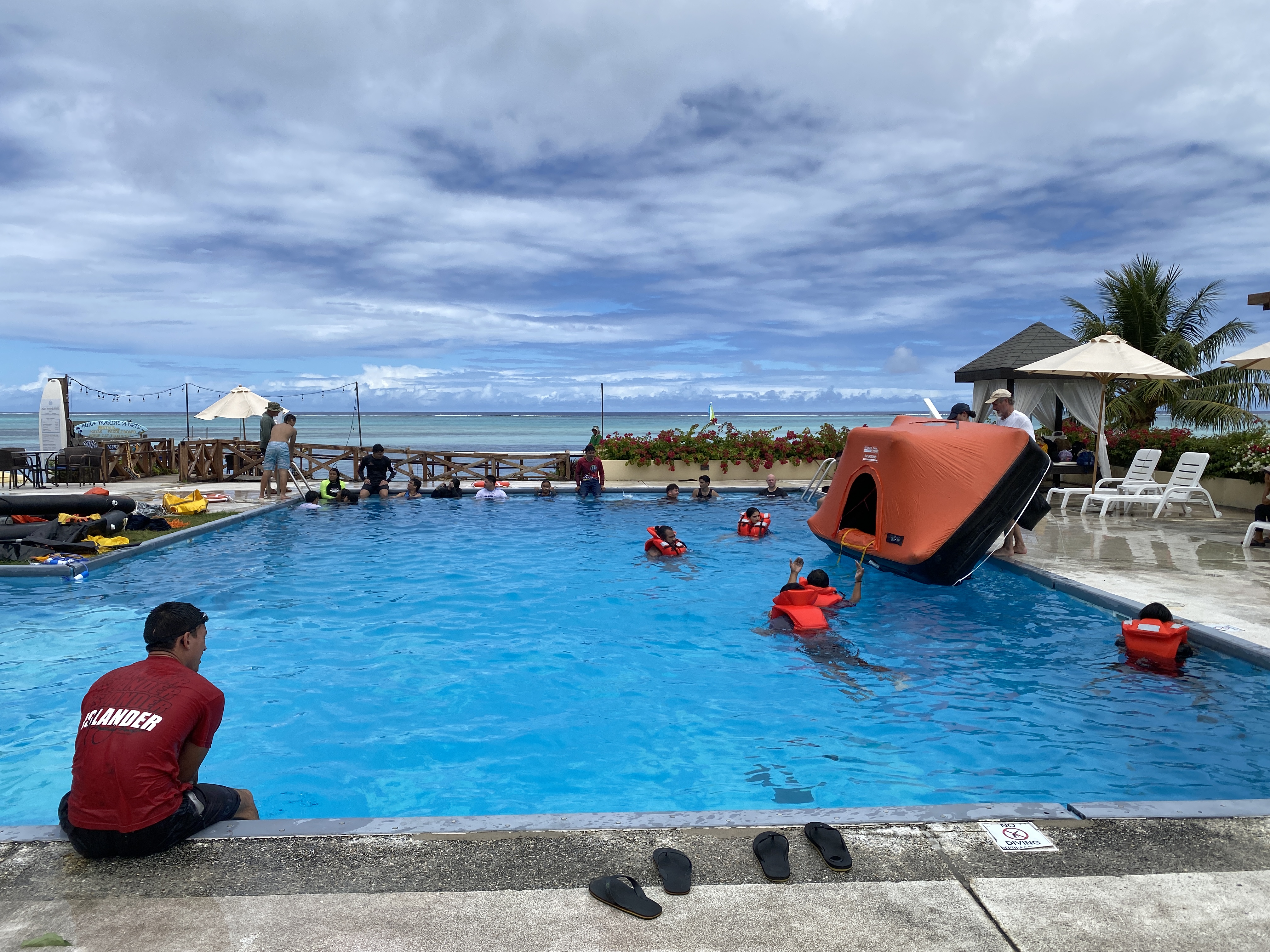 Western Pacific Maritime Academy students donning life vests wait in the Aqua Resort Club swimming pool for the start of their capsize drill on Wednesday, March 27.