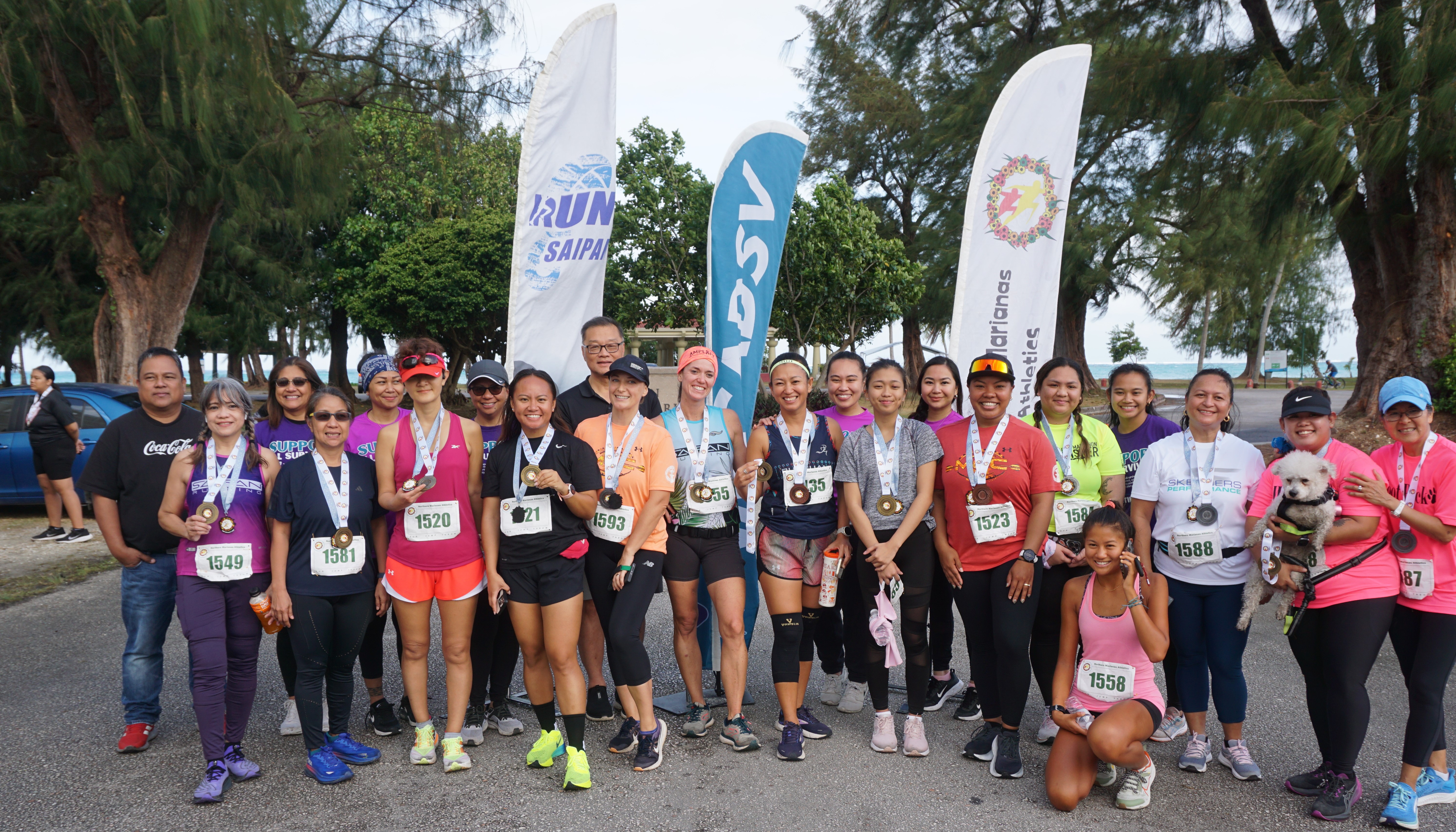 The medal winners pose for a photo with representatives of the Northern Marianas Coalition Against Domestic & Sexual Violence during the awards ceremony of Northern Marianas Athletics’ NMI 10K Women's Run 2024 at Micro Beach on Saturday.