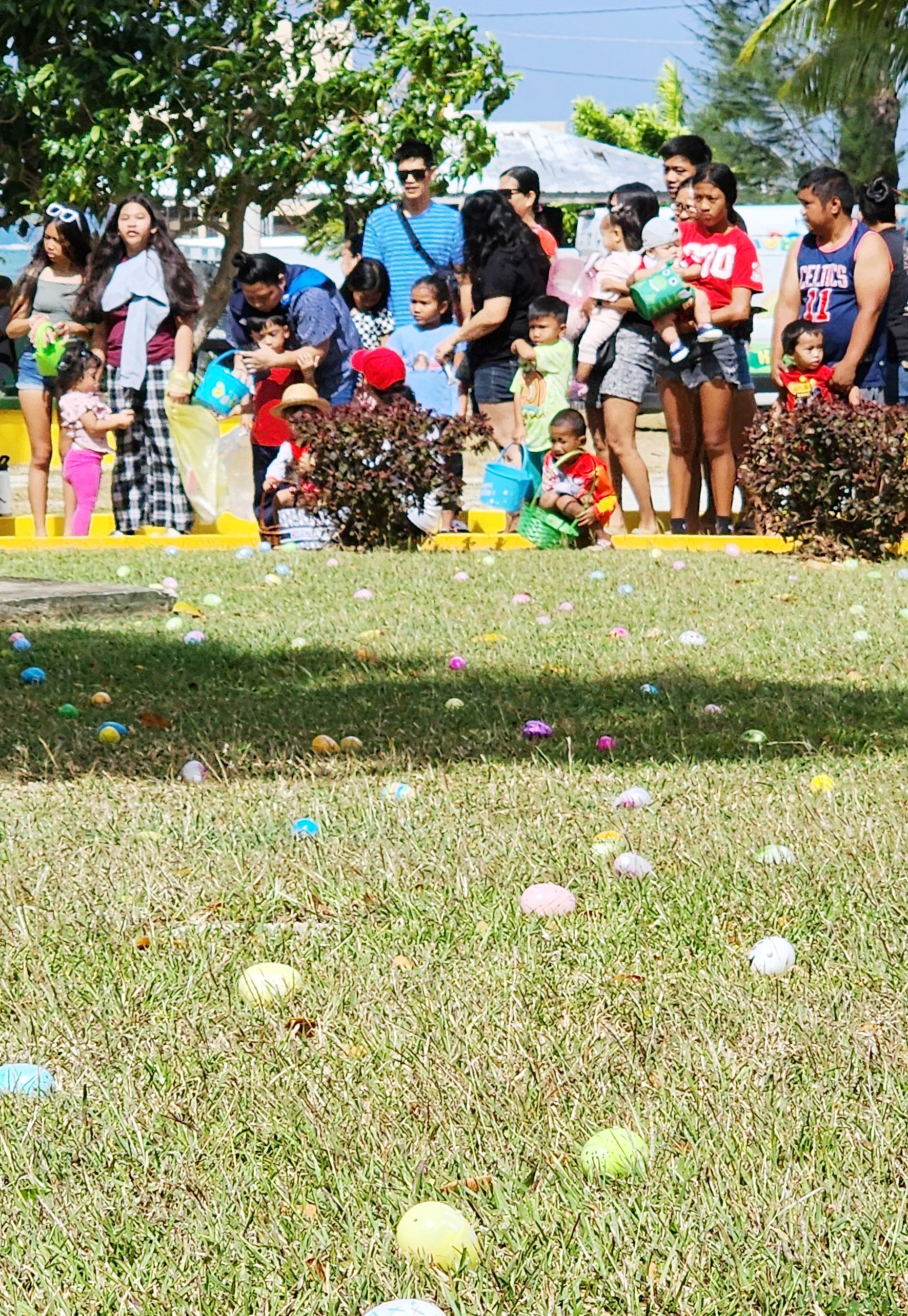 Easter eggs are scattered on the ground at Sugar King Park as children with their parents wait for the signal to start the egg hunt on Saturday morning.