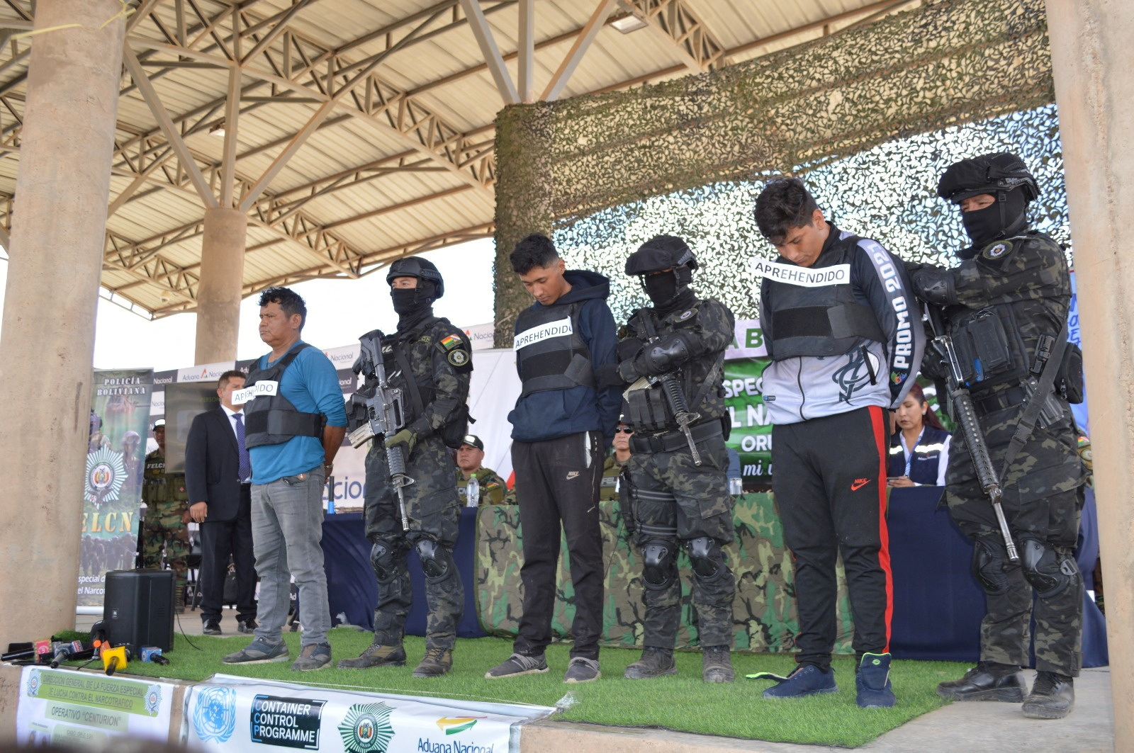 Members of Bolivian security forces stand next to detainees after police carried out the second-largest drug bust in the country's history, seizing more than 7.2 tons of cocaine hidden in two trucks transporting scrap iron for export to Europe through Chilean ports on the Pacific, in Oruro, Bolivia, March 19, 2024. 