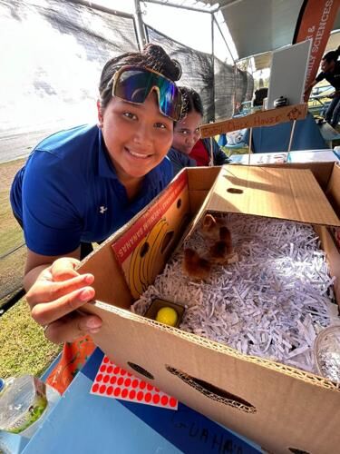 AmeriCorps service member Keniann Susuico pauses for a picture with baby chicks during the Migratory Bird Celebration on Feb. 17, 2024. 