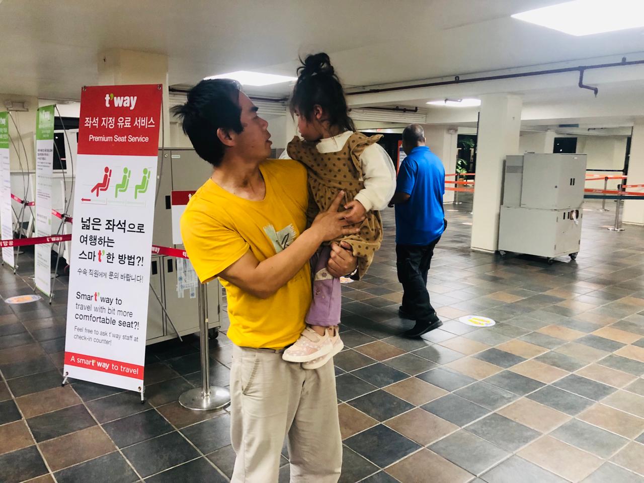 Xu Yuejun tries to comfort his daughter, Ziyu, who was crying at the Francisco C. Ada/Saipan International Airport.