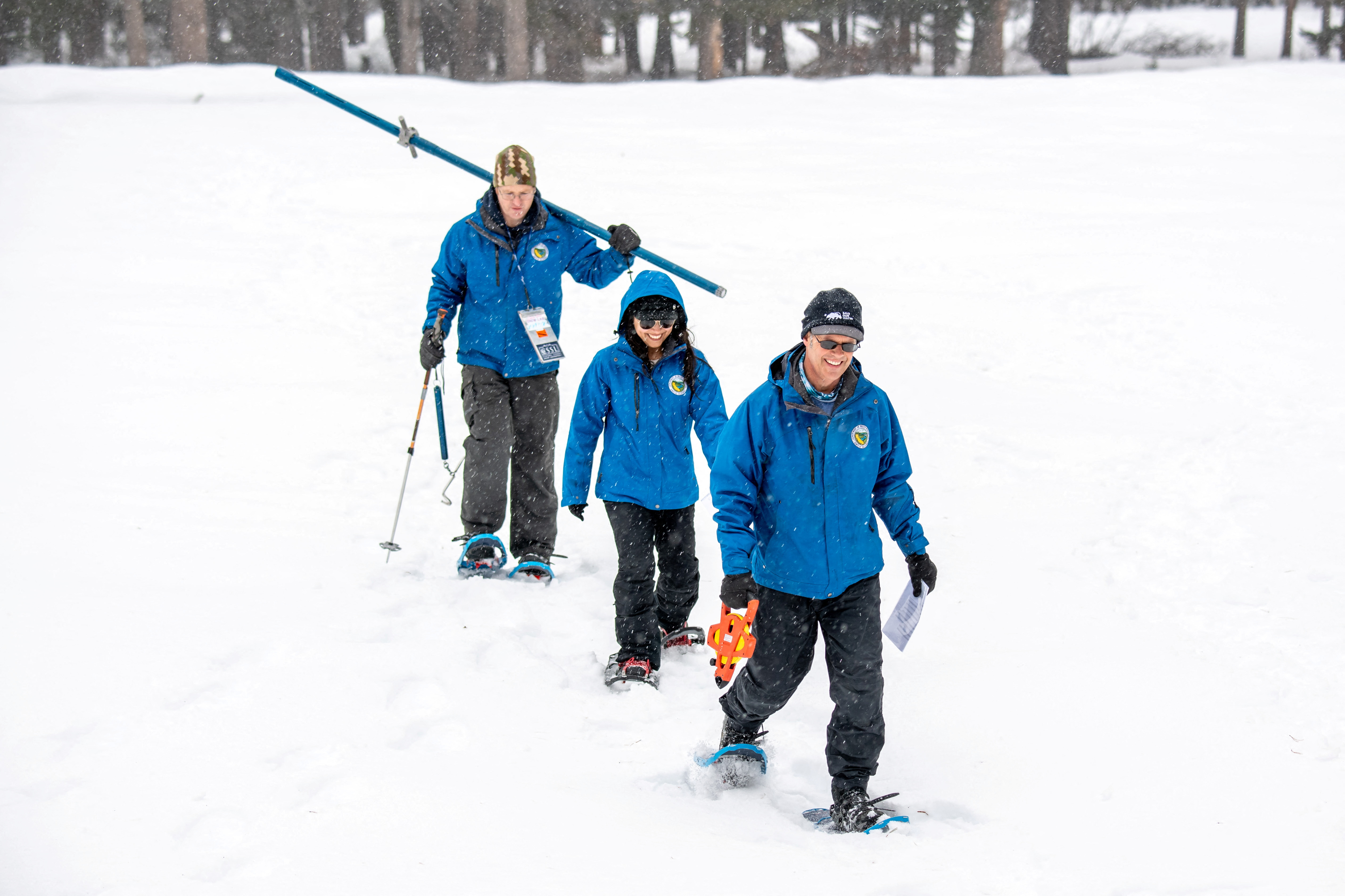Anthony Burdock, Water Resources Engineer, Angelique Fabbiani-Leon, State Hydrometeorologist, and Andy Reising, Water Resources Engineer, all from the California Department of Water Resources Snow Surveys and Water Supply Forecasting Unit, walk in the deep snow during the measurement phase of the third media snow survey of the 2024 season at Phillips Station in the Sierra Nevada Mountains, California, U.S., February 29, 2024. 