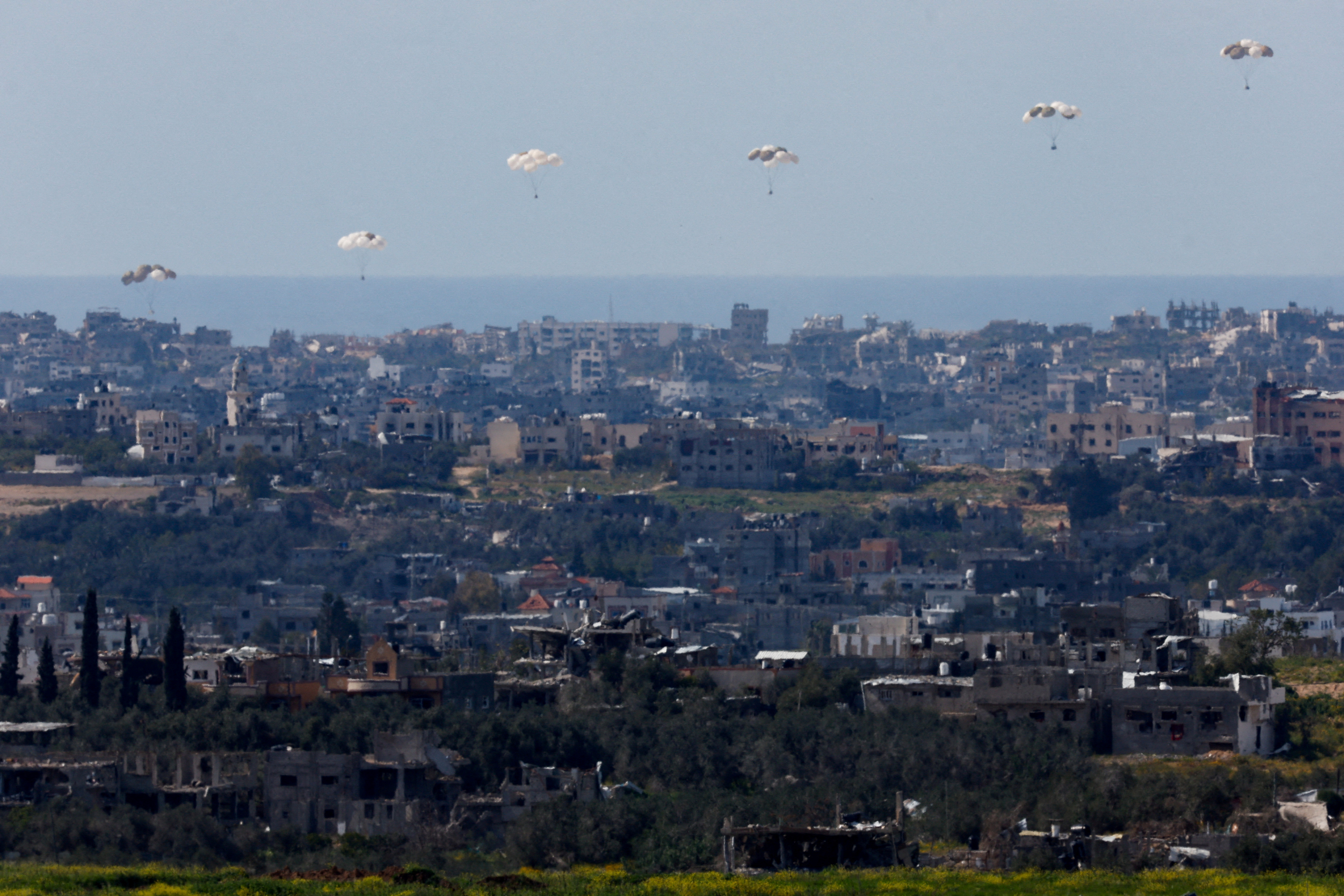 Packages fall towards northern Gaza after being dropped from a military aircraft, March 9, 2024. 