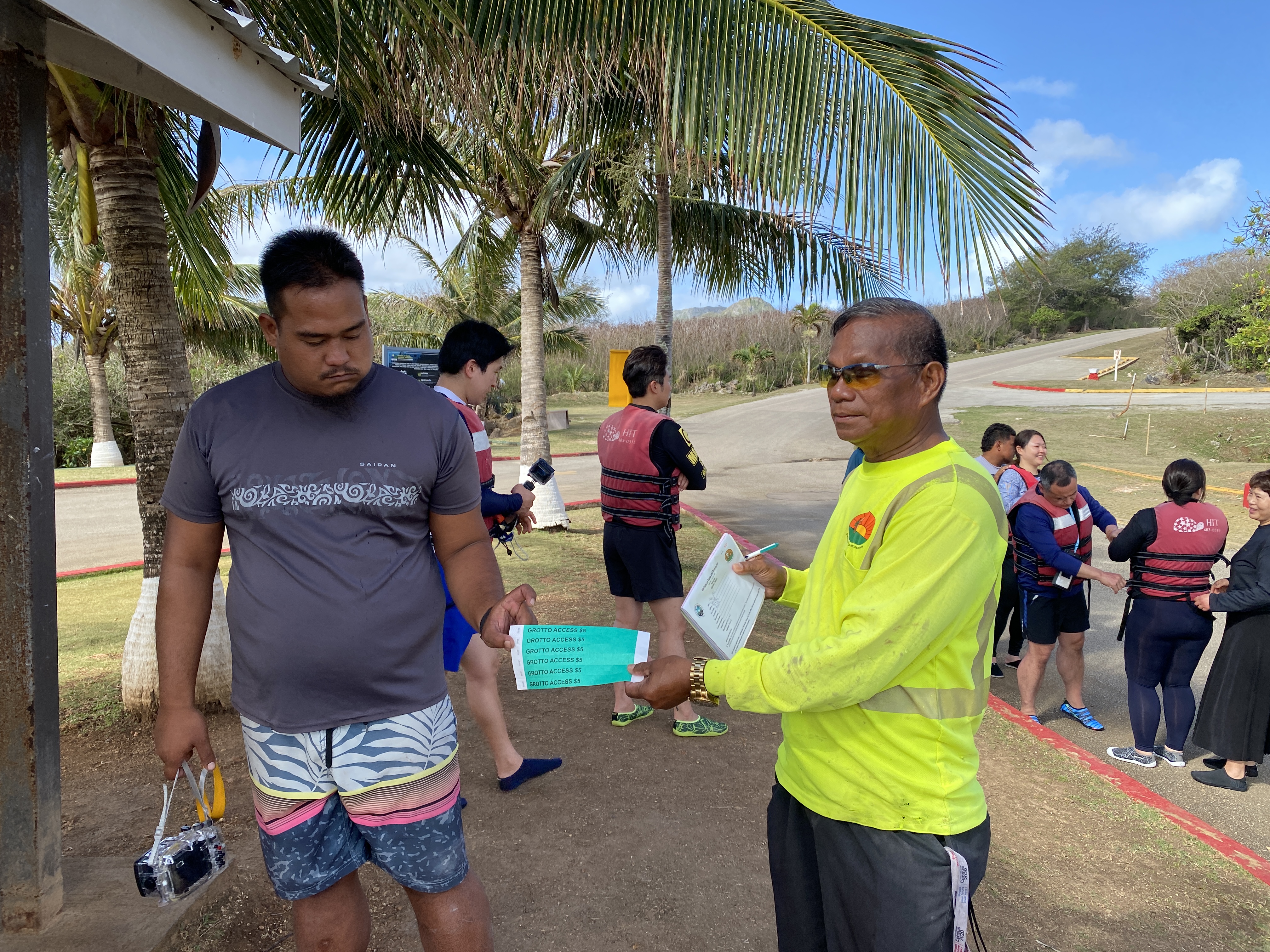 Ed Santos, who works a guide, and Max Aguon of the Division of Parks and Recreation, display Grotto entrance wristbands.