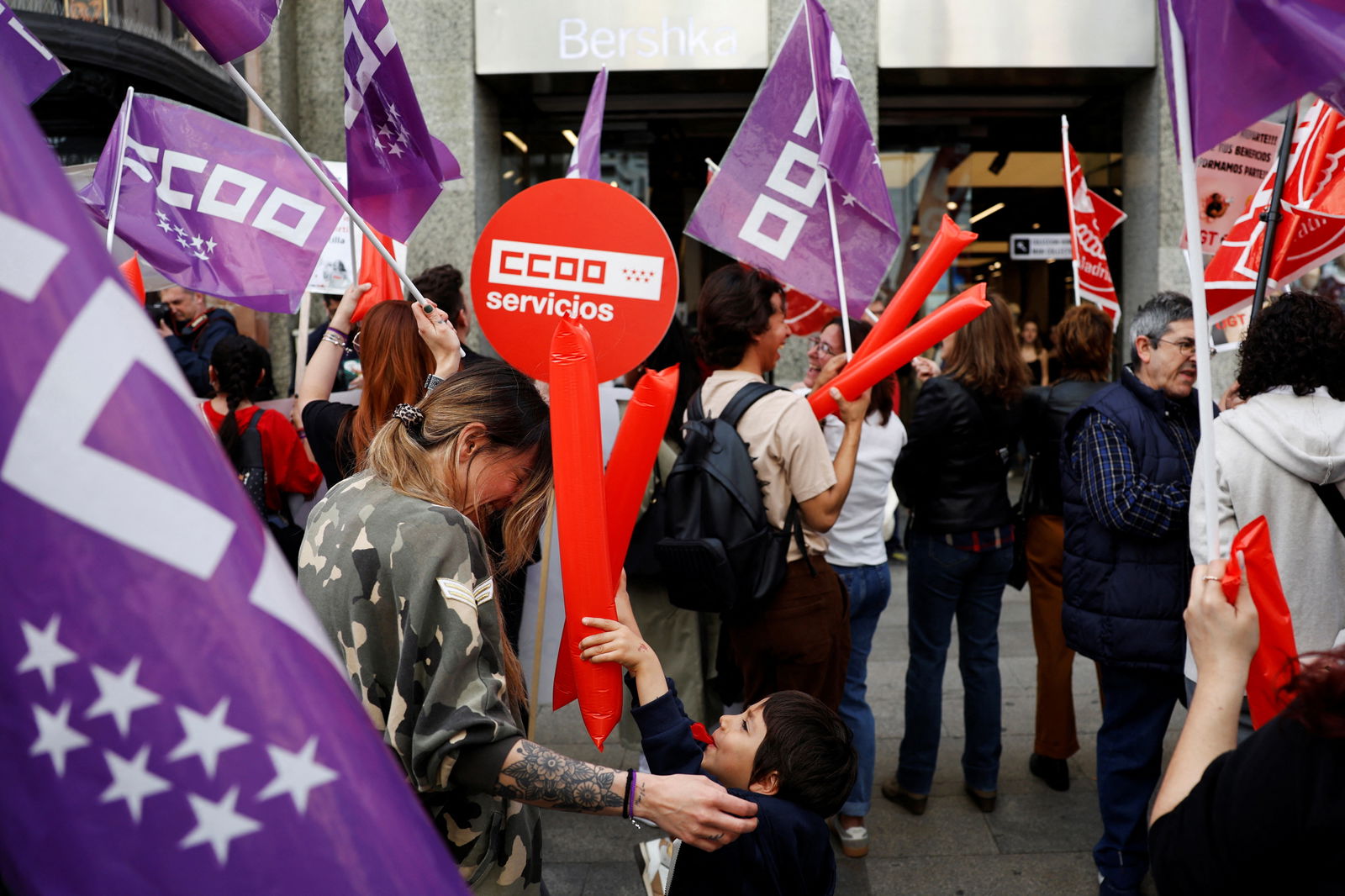 Laura Diaz and her son Marco, 5, play as they take part in a protest in front of a Bershka store, demanding better benefits for workers after the company posted a record profit, in Madrid, Spain, March 22, 2024. 
