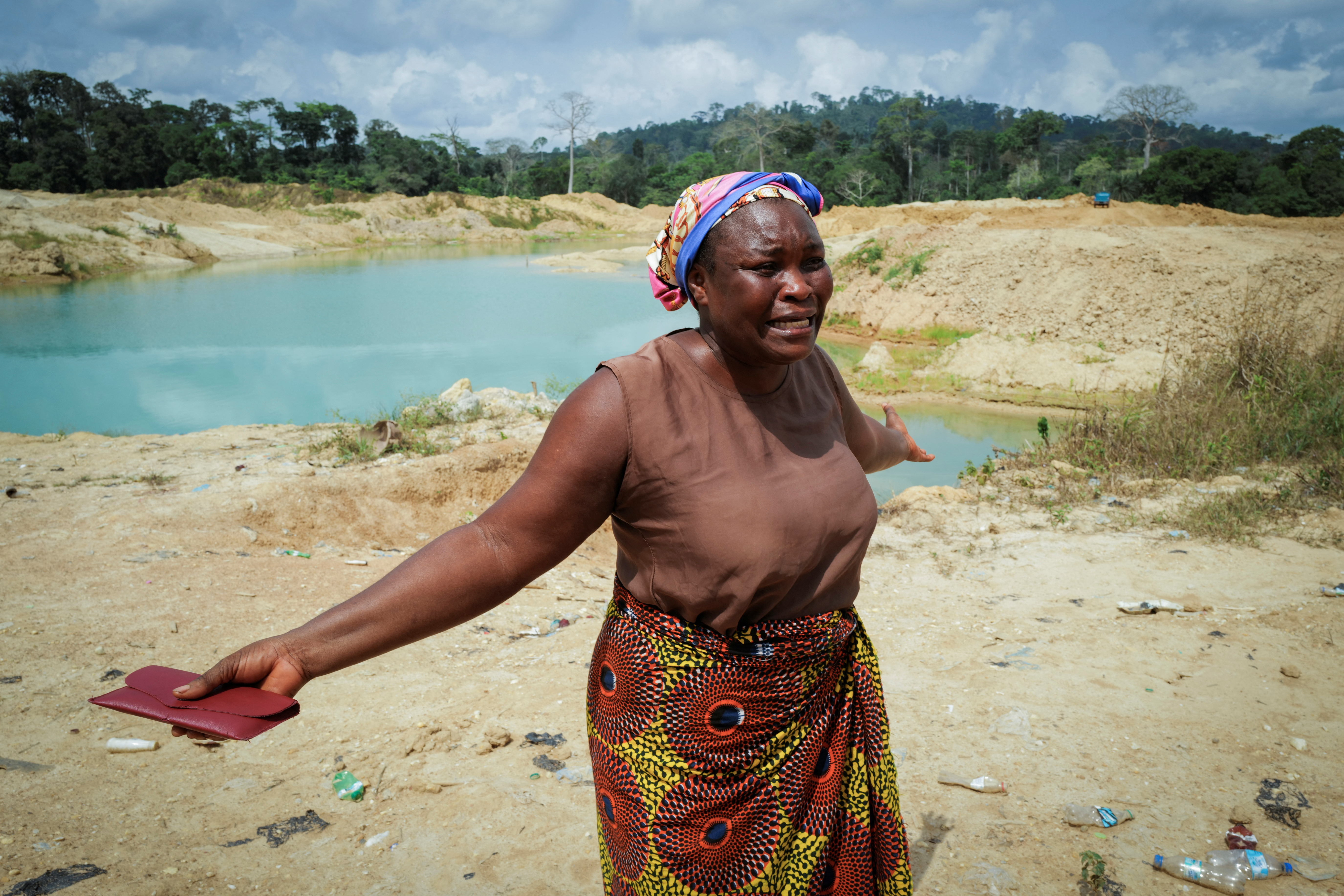 Janet Gyamfi, 52, a cocoa farmer, reacts as she visits her cocoa plantation destroyed by illegal gold mining in the Samreboi community in the Western Region, Ghana, February 26, 2024. Surveying the stripped landscape of her farm - dotted with pools of cyanide-tainted, tea colored waste water left by illegal gold miners - is enough to make Gyamfi break down. Only last year, the 27-hectare plot in western Ghana was covered with nearly 6,000 cocoa trees. Today, less than a dozen remain. "This farm was my only means of survival," the divorcee told Reuters, tears streaming down her cheeks. "I planned to pass it on to my children."