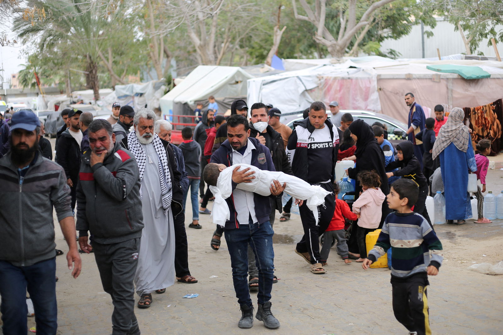 SENSITIVE MATERIAL. THIS IMAGE MAY OFFEND OR DISTURB. A mourner carries the body of a Palestinian child killed in an Israeli strike, amid the ongoing conflict between Israel and Hamas, in Khan Younis in the southern Gaza Strip March 29, 2024. 