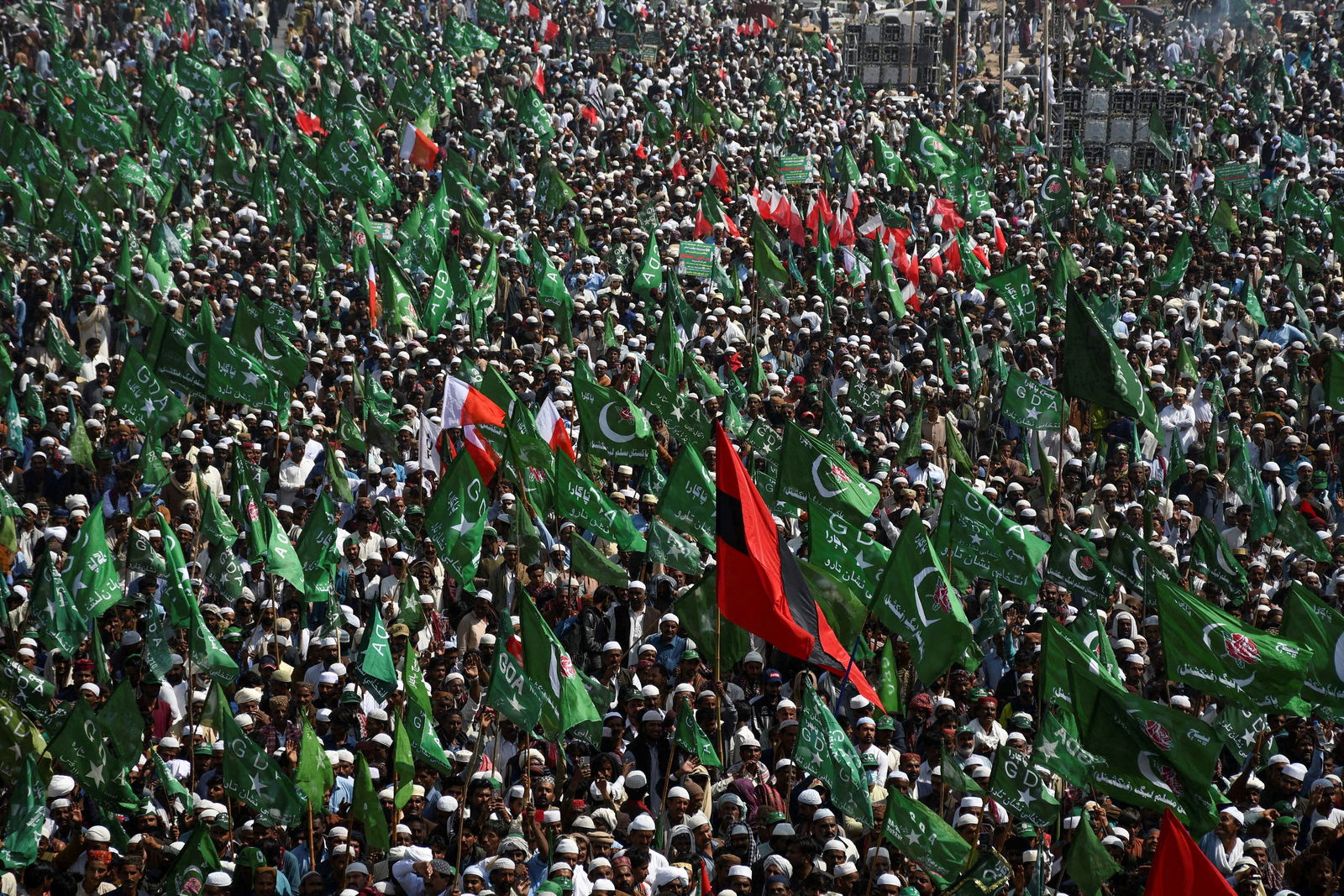 FILE PHOTO: Supporters of the Grand Democratic Alliance (GDA), an alliance of political parties, carry flags as they gather for a sit-in protest against, what they call election rigging and are demanding free and fair results of the general elections along the main Highway in Jamshoro, Pakistan February 16, 2024. 