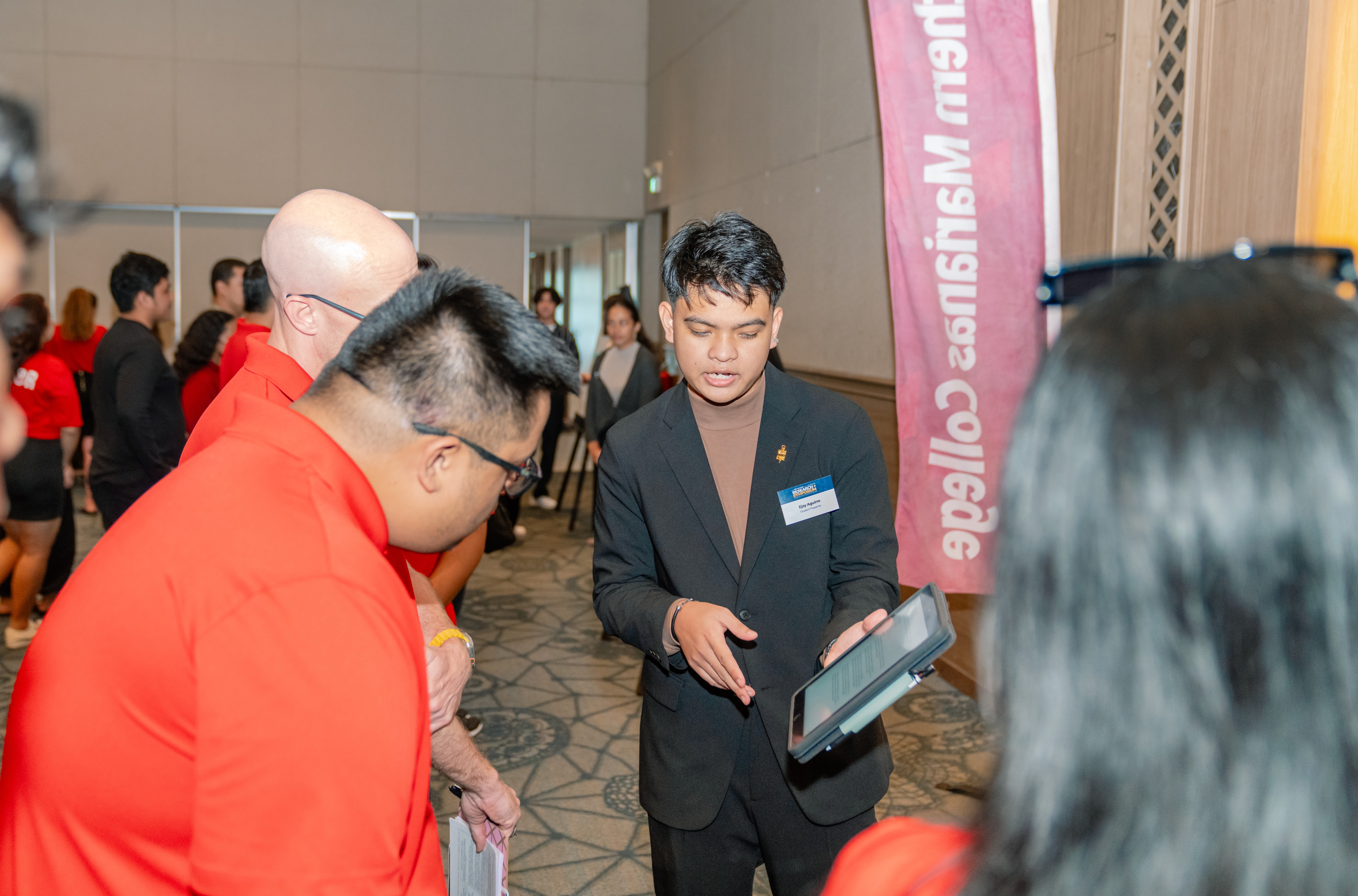 Ejay Aguirre, NMC student, presents his research to symposium judges.