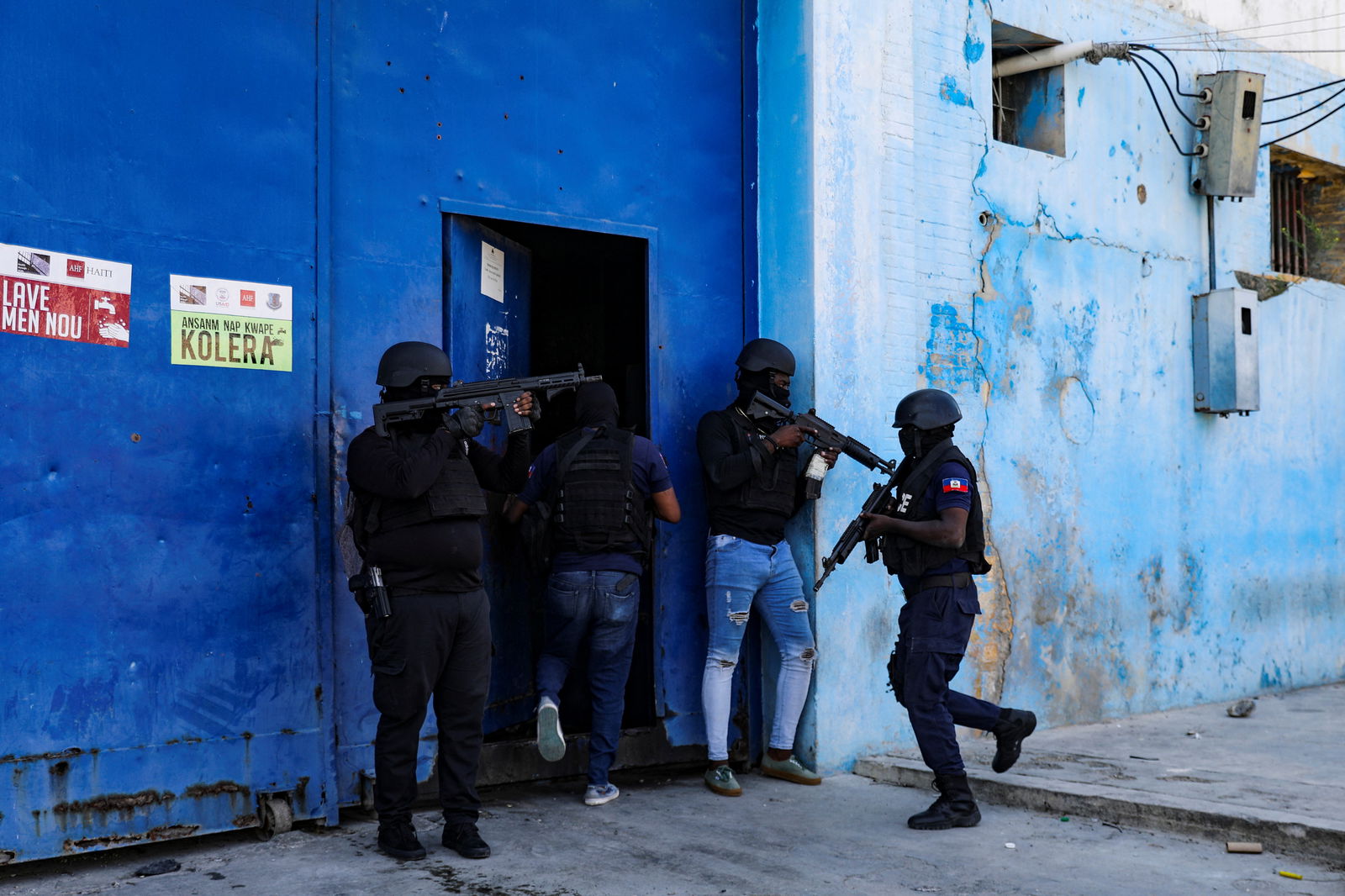 Police officers keep watch at the entrance to the National Penitentiary following a fire, as a powerful gang leader in Haiti has issued a threatening message aimed at political leaders who would take part in a still-unformed transition council for the country, in Port-au-Prince, Haiti, March 14, 2024. 