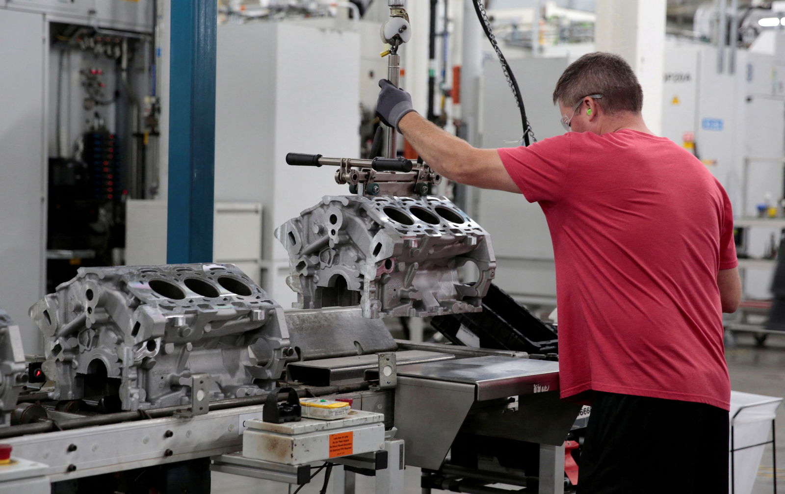 FILE PHOTO: A General Motors assembly worker loads engine block castings on to the assembly line at the GM Romulus Powertrain plant in Romulus, Michigan, U.S. August 21, 2019. 