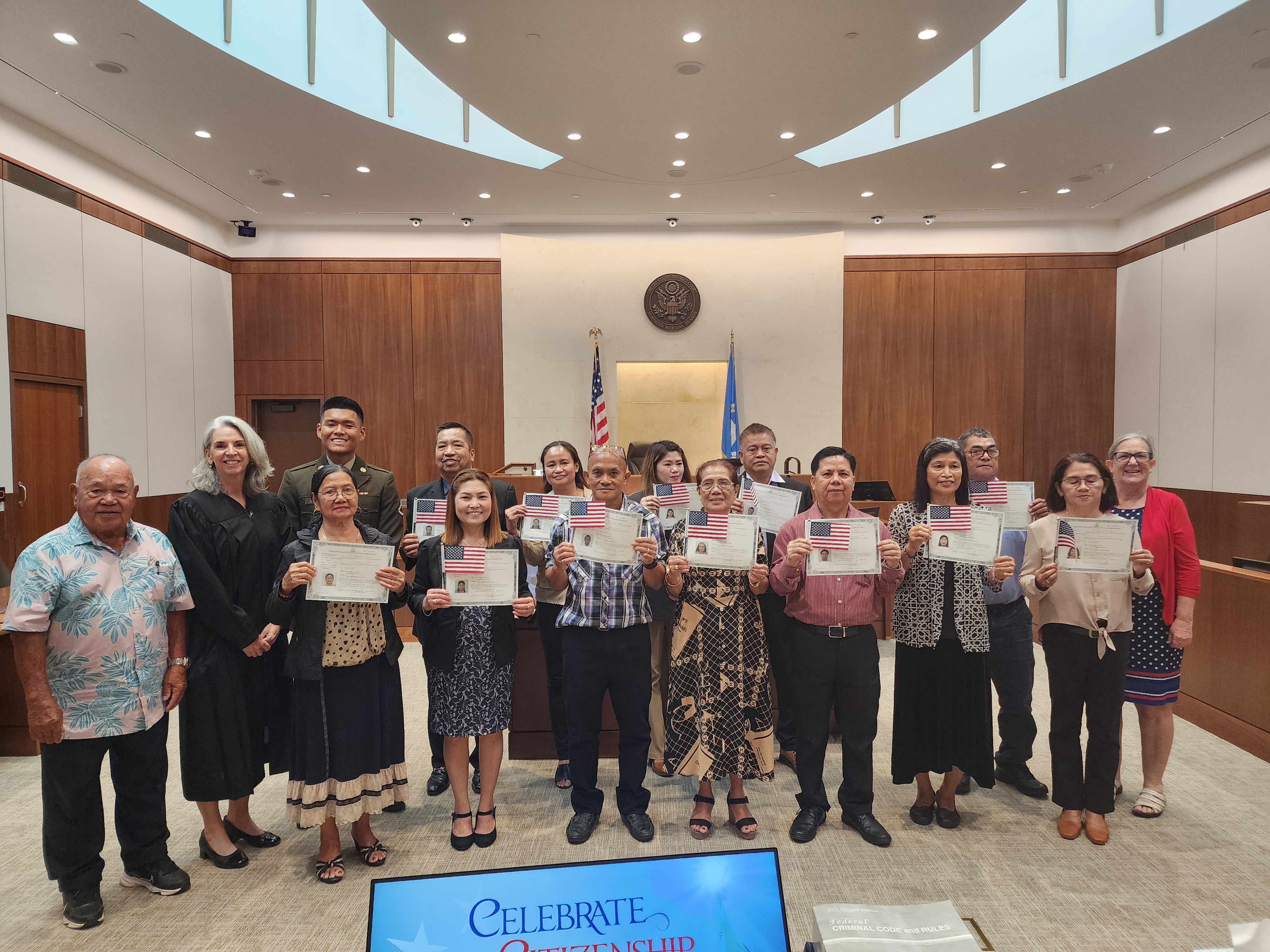 Former Lt. Gov. Pete A. Tenorio, Magistrate Judge Heather Kennedy and U.S. Citizenship and Immigrations Services Officer Patricia Phelan pose for a photo with the 13 new U.S. citizens Tuesday at the District Court for the NMI.
