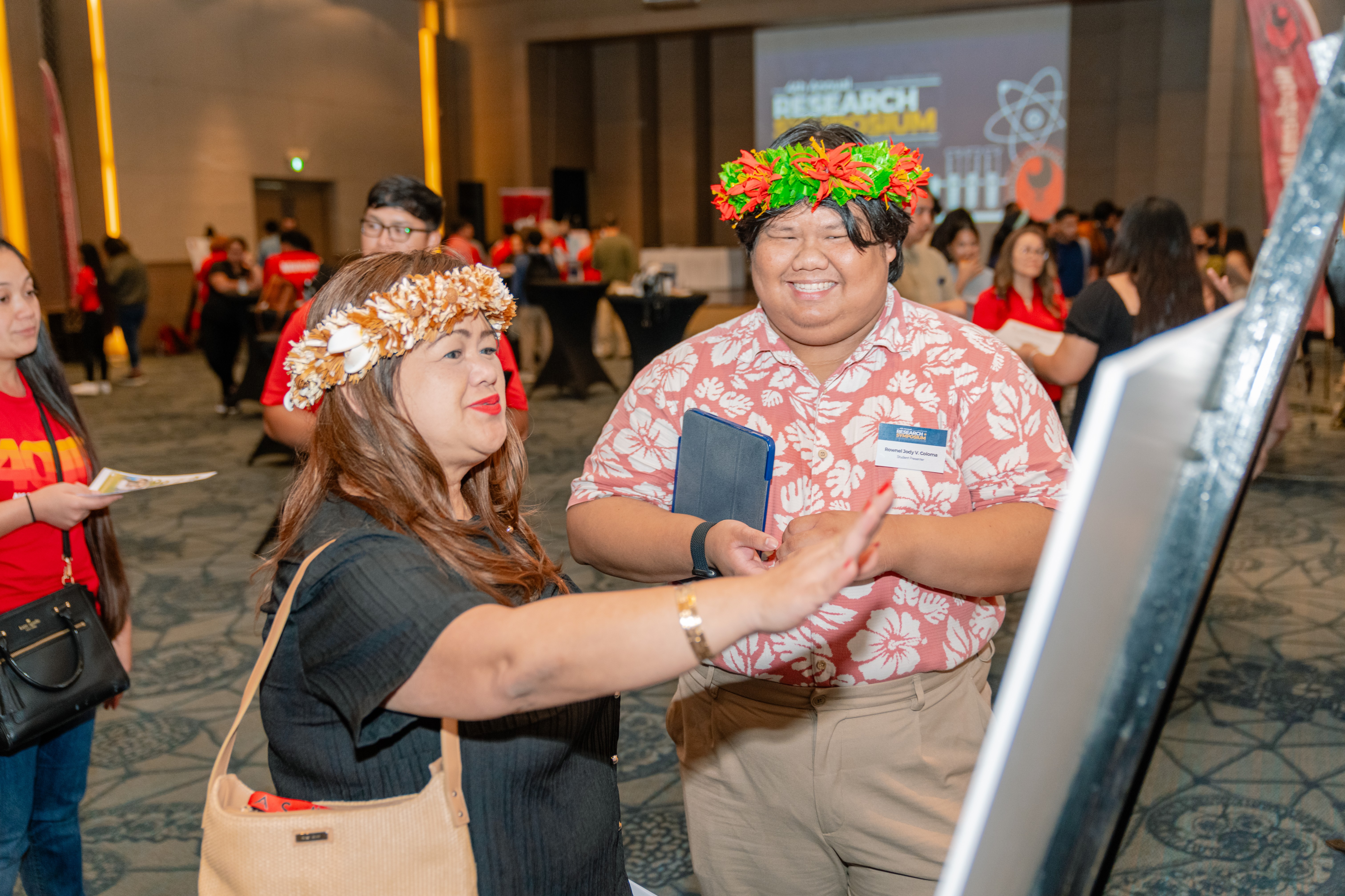 Dean Charlotte Cepeda chats with Rownel Jody Coloma regarding his research.