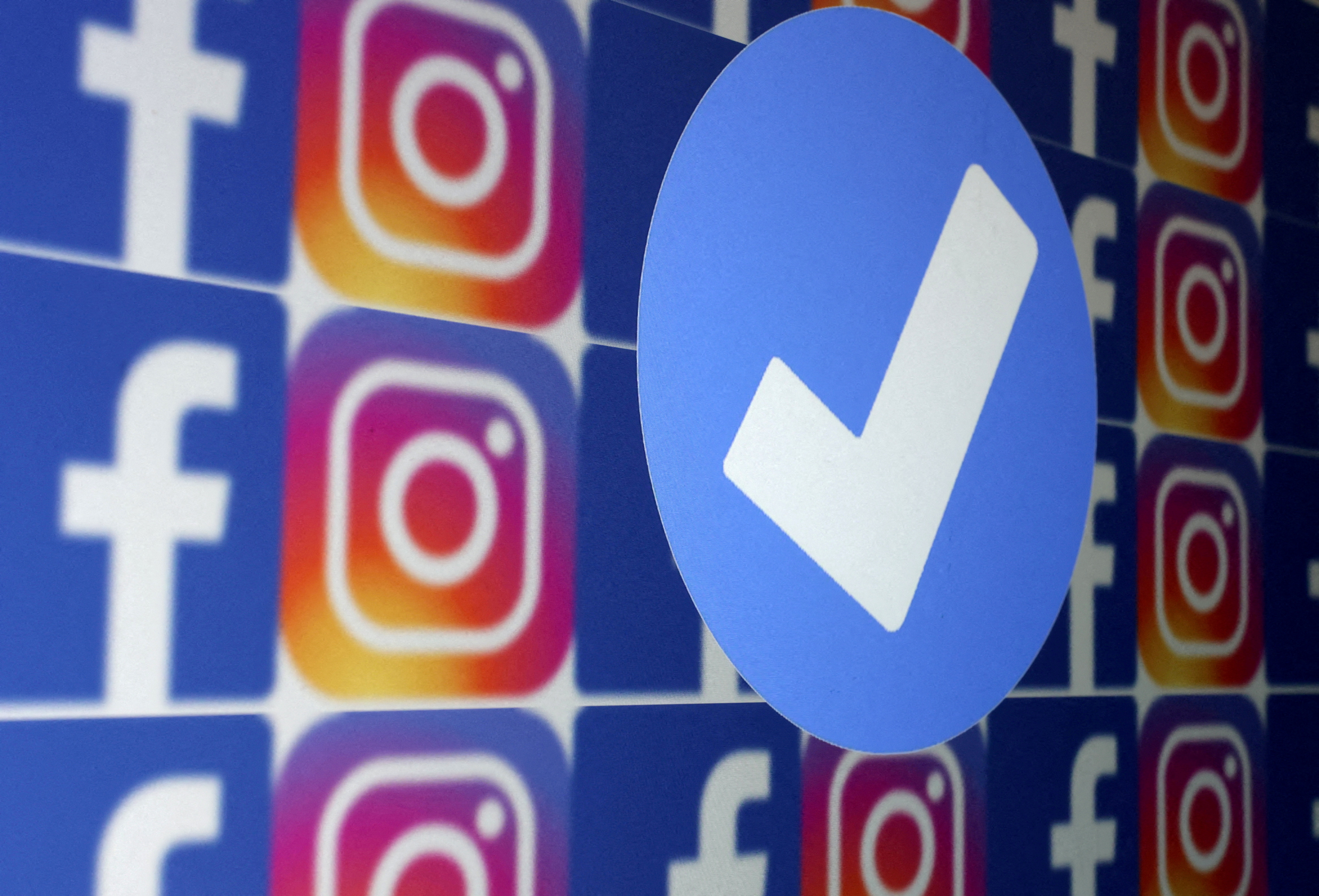 FILE PHOTO: A blue verification badge and the logos of Facebook and Instagram are seen in this picture illustration taken January 19, 2023. 