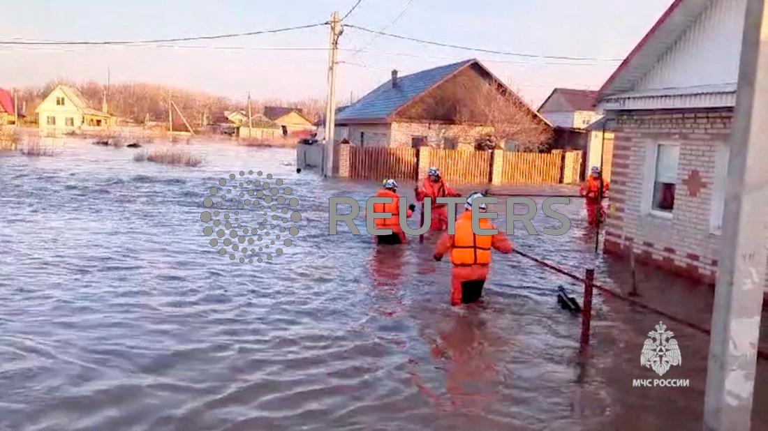 Rescuers make their way on a flooded residential area in the city of Orsk, Russia, April 6, 2024, in this still image taken from video. 