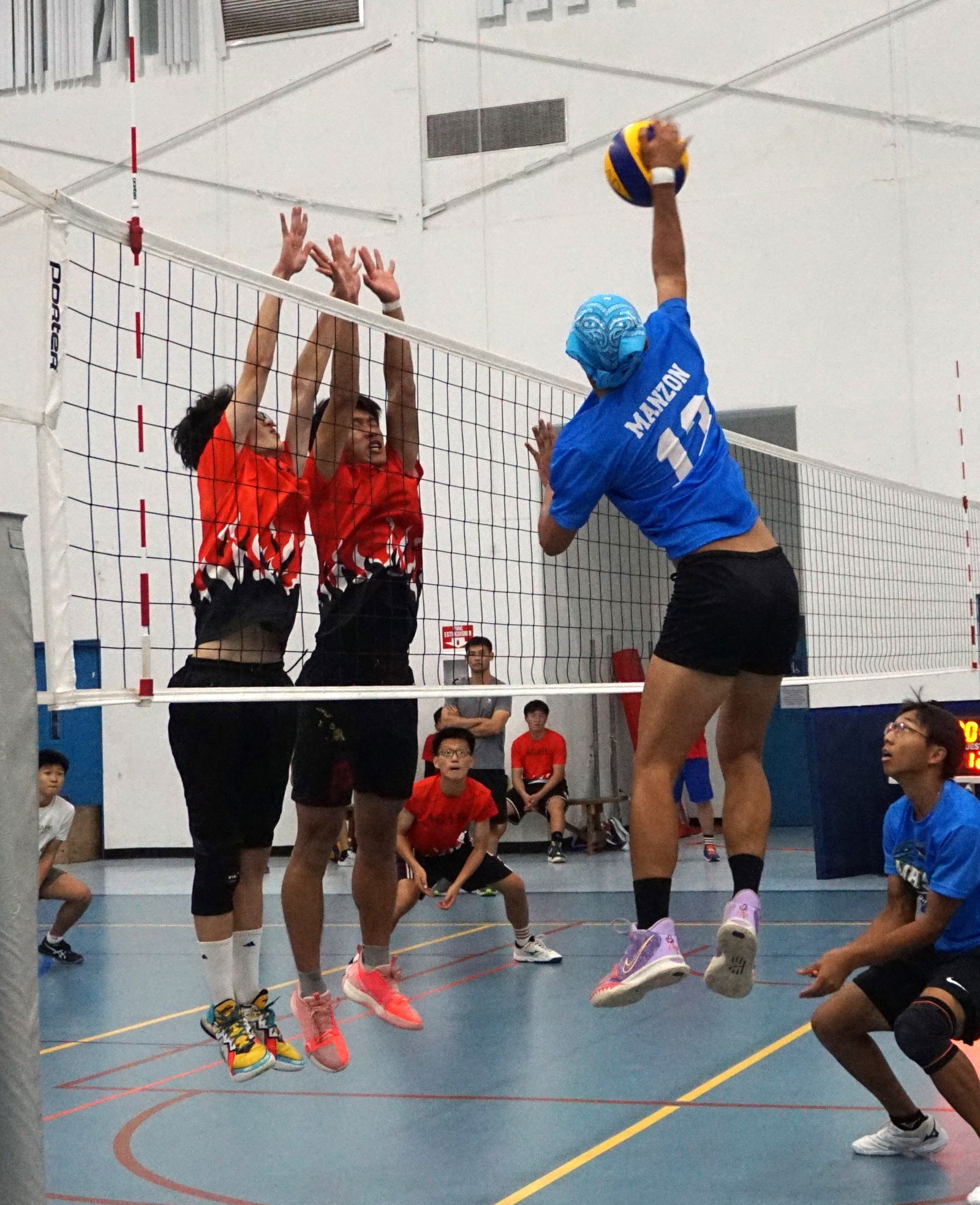 Two Agape Christian School defenders reach out to block Marianas High School Manzon's spike during a boys high school division game in a previous season of the NMIVA-PSS Interscholastic Volleyball League at the MHS gym.