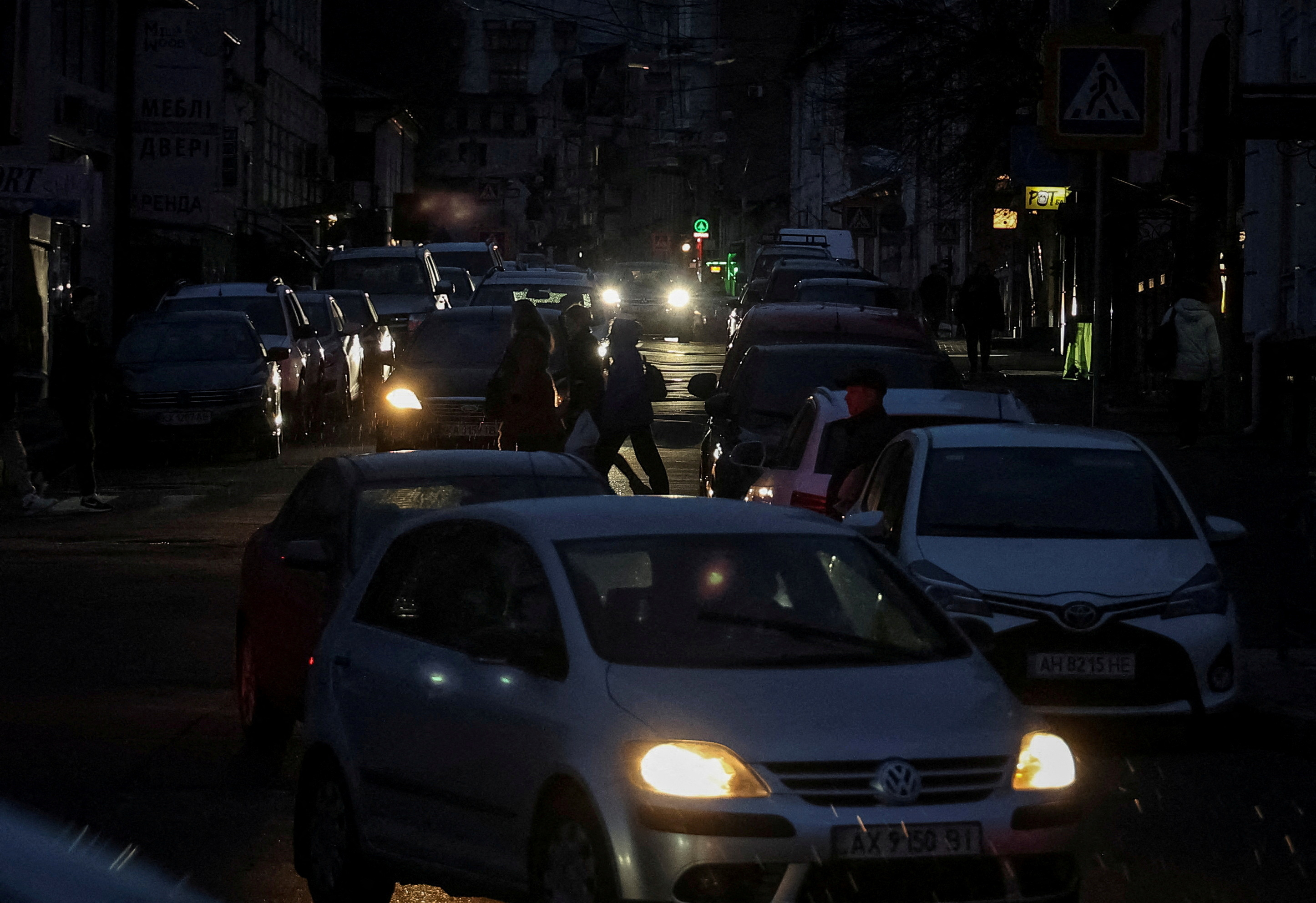 FILE PHOTO: People and traffic move through the city centre without electricity after critical civil infrastructure was hit by Russian missile attacks, amid Russia's invasion of Ukraine, in Kharkiv, March 26, 2024. 