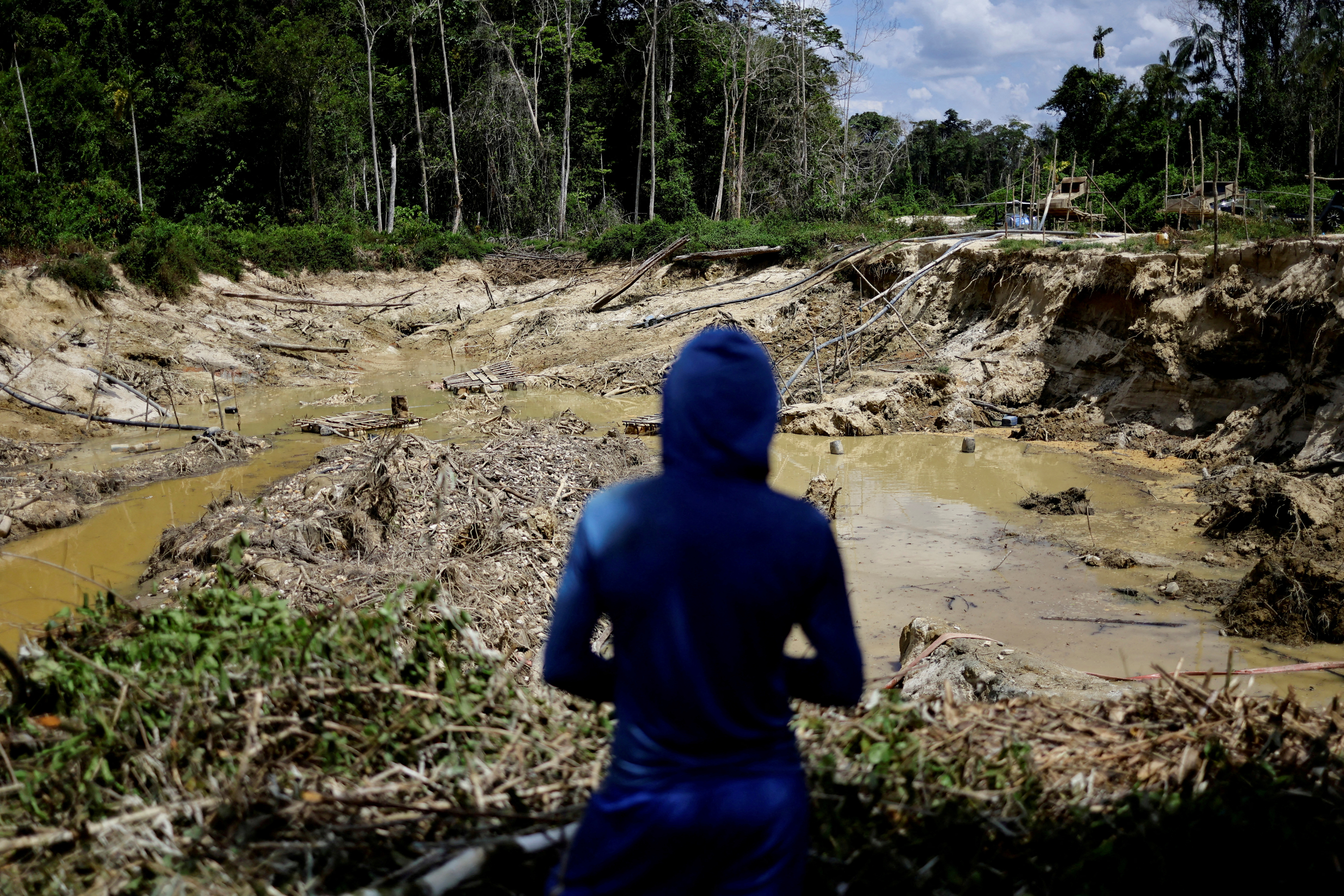 FILE PHOTO: An illegal miner looks at a destroyed forest area, while being detained by a members of the Special Inspection Group from the Brazilian Institute of Environment and Renewable Natural Resources (IBAMA) during an operation against illegal mining in Yanomami Indigenous land, Roraima state, Brazil, December 6, 2023. 
