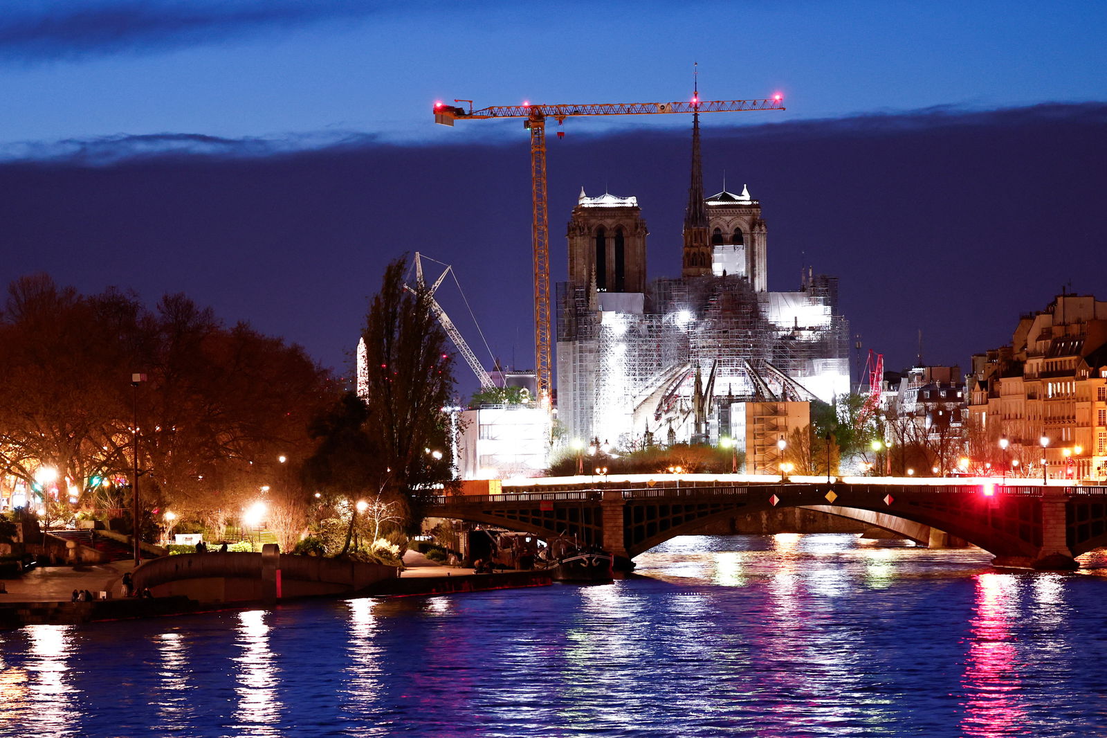 FILE PHOTO: A night view shows the Notre-Dame de Paris Cathedral, which was ravaged by a fire in 2019, with a new spire, surmounted by the rooster and the cross, as restoration works continue in Paris, France, March 30, 2024. 
