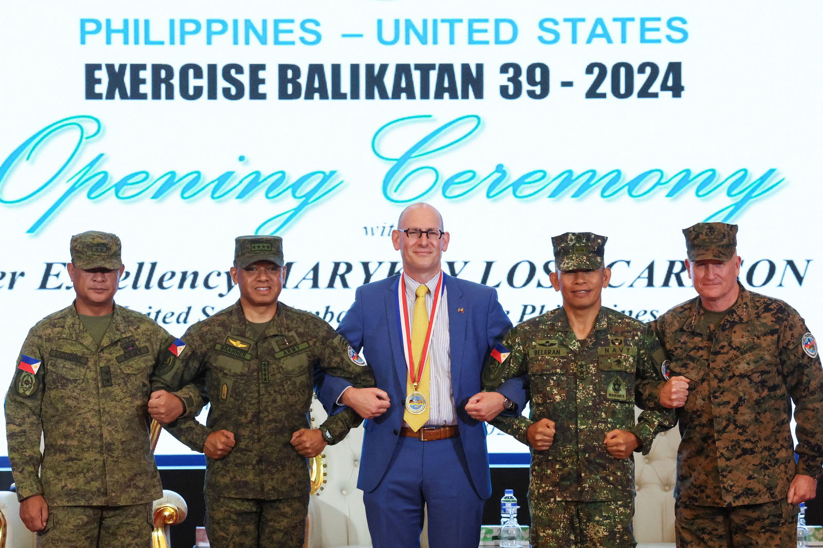 Philippine Exercise Director Maj. Gen, Marvin Licudine, Philippine Army Chief of Staff Romeo Brawner Jr., U.S. Embassy representative Robert Ewing, Philippine Army Deputy Chief of Staff for Education, Training and Doctrine Maj. Gen. Noel Beleran, and U.S. Exercise Director Lt. Gen. William Jurney link arms during the opening ceremony of the annual Philippines-U.S. joint military exercises or Balikatan, at the Armed Forces of the Philippines headquarters, in Quezon City, Metro Manila, April 22, 2024.