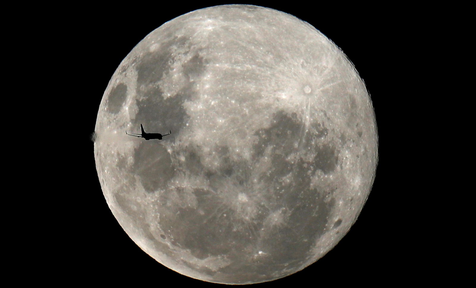 FILE PHOTO: A plane is pictured in front of the full moon in Curitiba, Brazil February 8, 2020. 