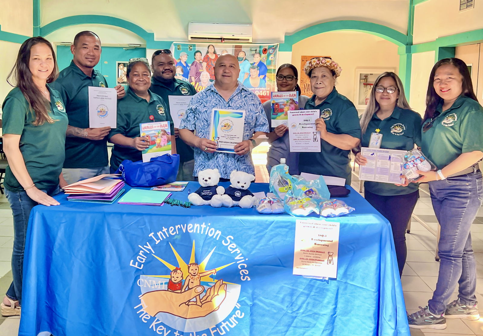 The Early Intervention Program team led by Director Robin L. Palacios, left, and Commissioner of Education Dr. Lawrence F. Camacho, center, at the Rota Aging Center pose for a photo while displaying brochures, flyers and other educational materials about the program.