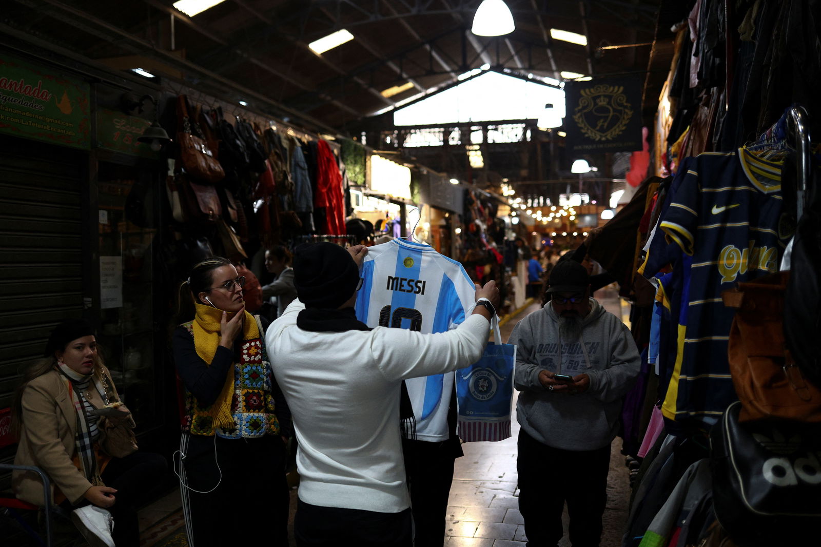 A shopper holds a t-shirt with the last name of Argentina's soccer star Lionel Messi at a market, as Argentina is battling inflation that is running on an annual basis above 275%, in Buenos Aires, Argentina, April 11, 2024. 