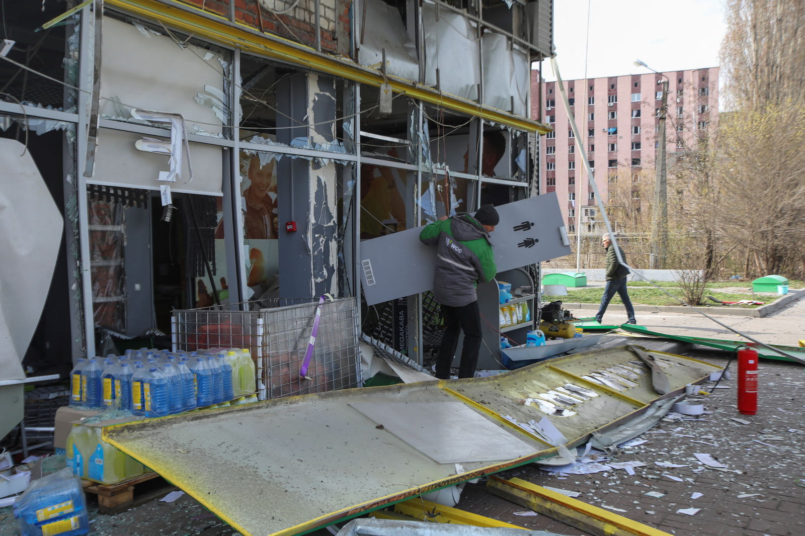 An employee carries out a door from a fuel station damaged during Russian missile and drone strikes, amid Russia's attack on Ukraine, in Kharkiv, Ukraine April 6, 2024. 