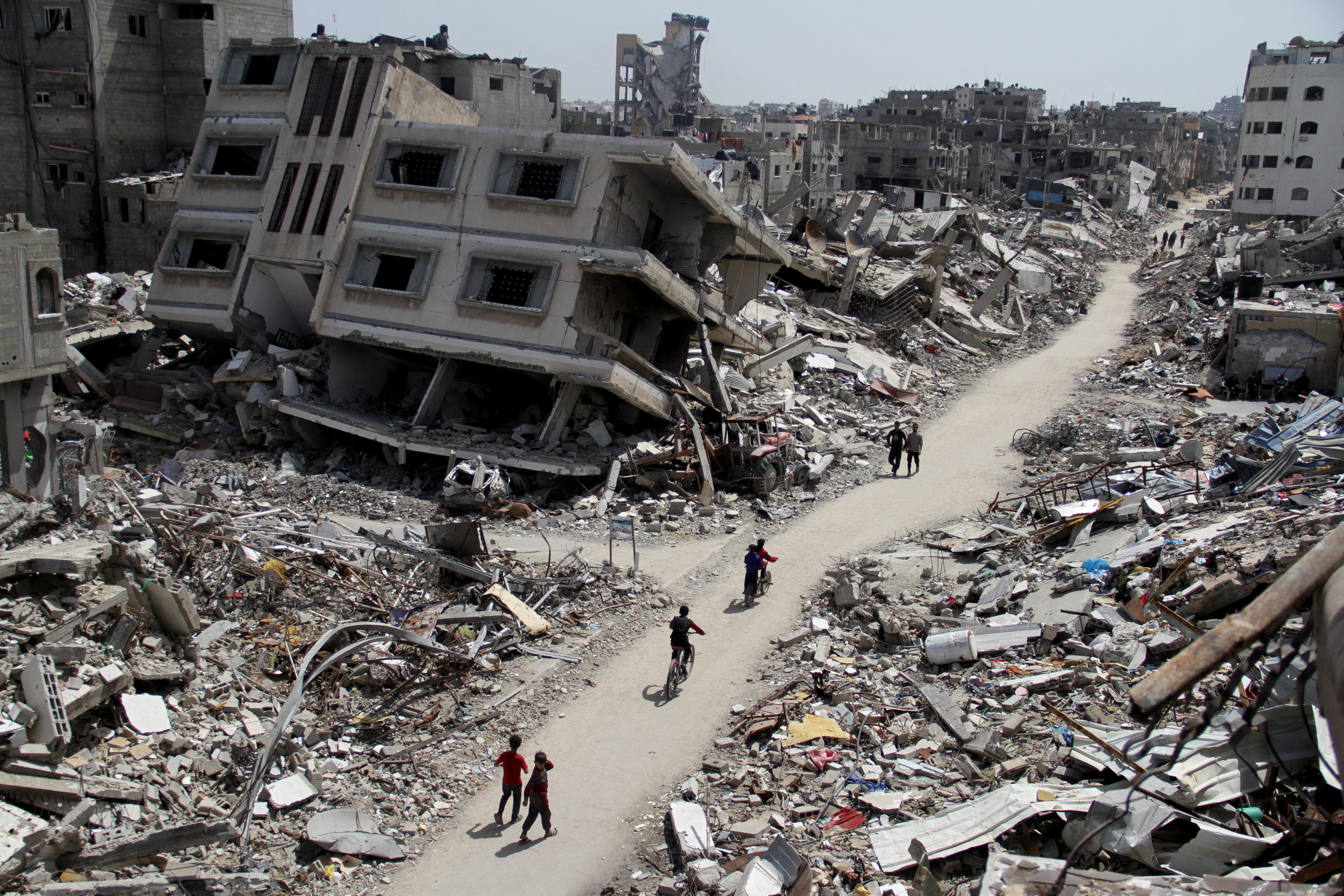 Palestinians ride bicycles past the ruins of houses and buildings destroyed during Israel’ military offensive, amid the ongoing conflict between Israel and the Palestinian Islamist group Hamas, in the northern Gaza Strip March 31, 2024. 