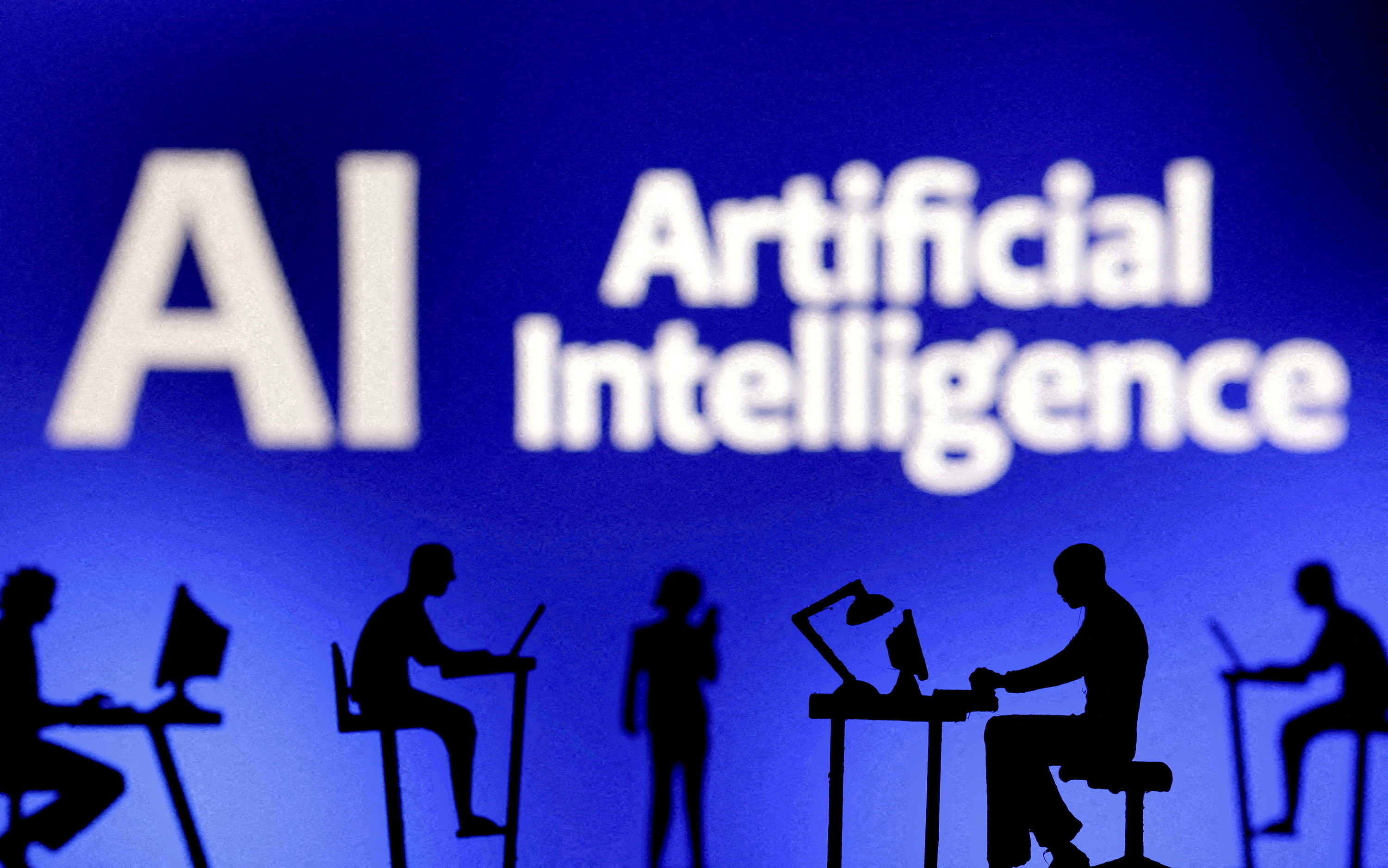FILE PHOTO: Figurines with computers and smartphones are seen in front of the words "Artificial Intelligence AI" in this illustration taken, February 19, 2024. 
