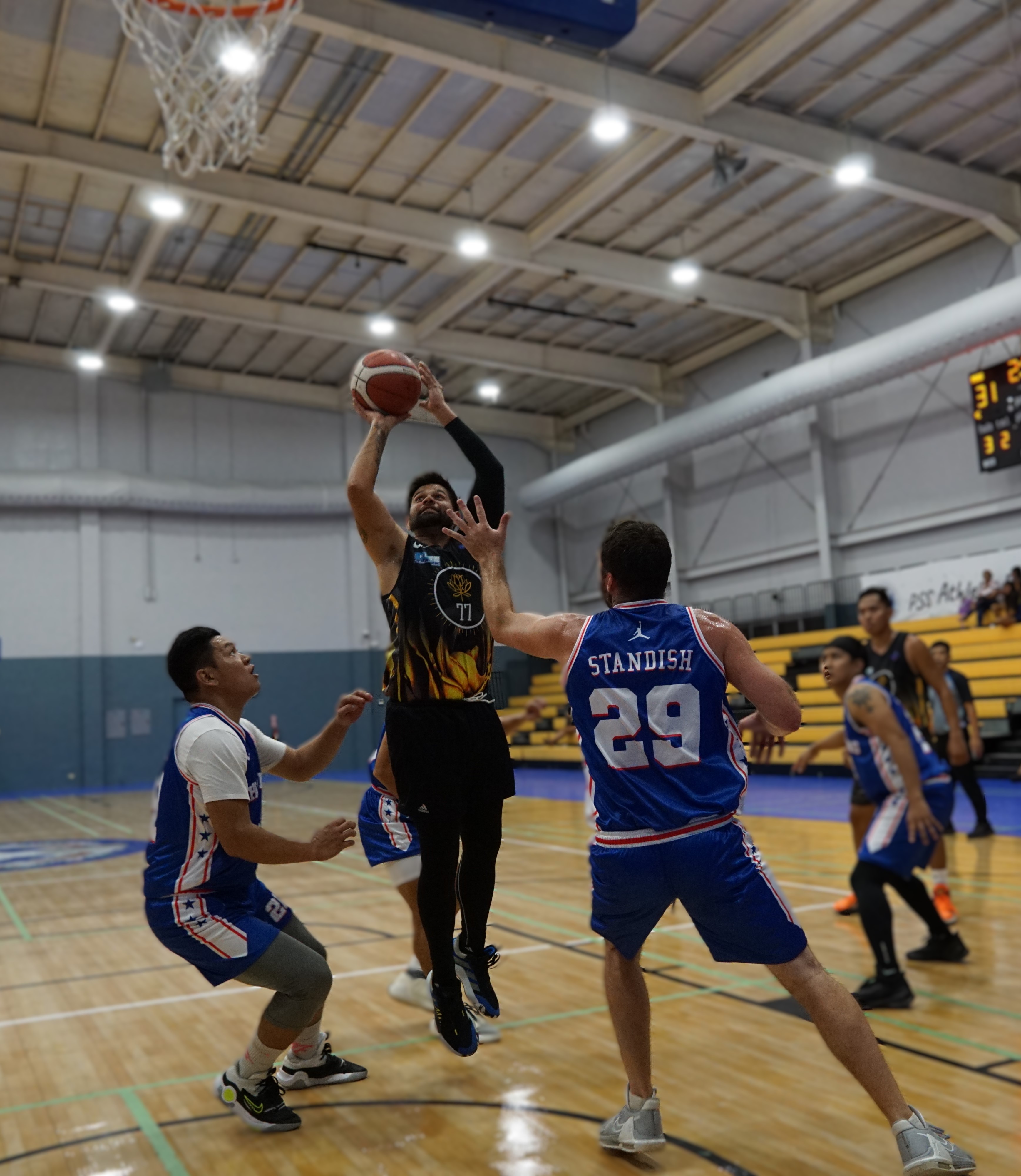 Pegs' James Kintz finishes at the rim over two defenders during a game against New Changming in the men's open division of the Michelob Ultra Cup 2024 at the Ada gym on Monday.