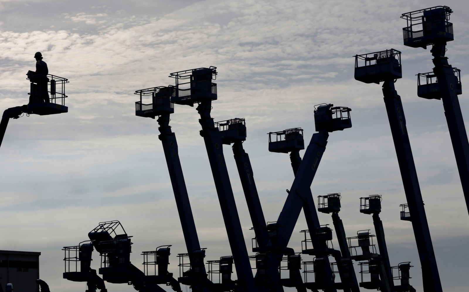 A worker stands on a crane which is parked at a construction site at Keihin industrial zone in Kawasaki, south of Tokyo, June 13, 2012. 