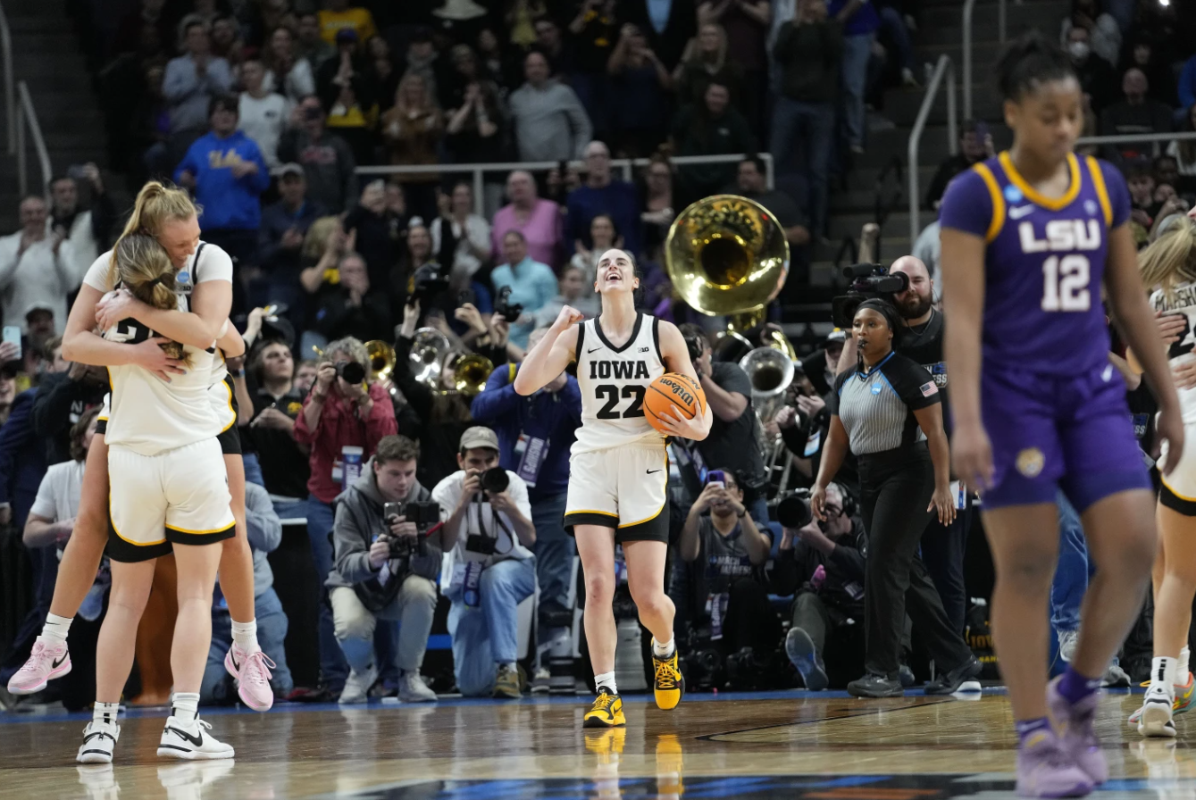 Iowa guards Caitlin Clark (22), Sydney Affolter (3) and Kate Martin (20) celebrate after defeating LSU in an Elite Eight round college basketball game, Monday, April 1, 2024 in Albany, N.Y.