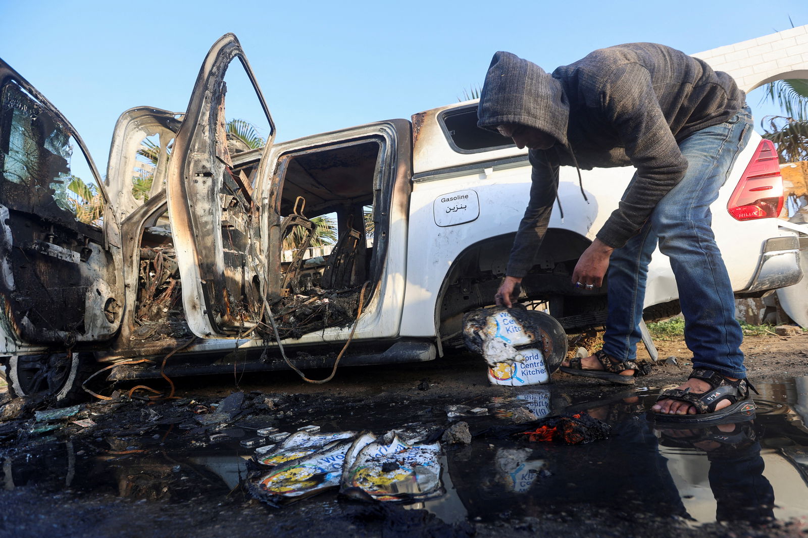 A Palestinian inspects near a vehicle where employees from the World Central Kitchen (WCK), including foreigners, were killed in an Israeli airstrike, according to the NGO as the Israeli military said it was conducting a thorough review at the highest levels to understand the circumstances of this "tragic" incident, amid the ongoing conflict between Israel and Hamas, in Deir Al-Balah, in the central Gaza, Strip April 2, 2024.