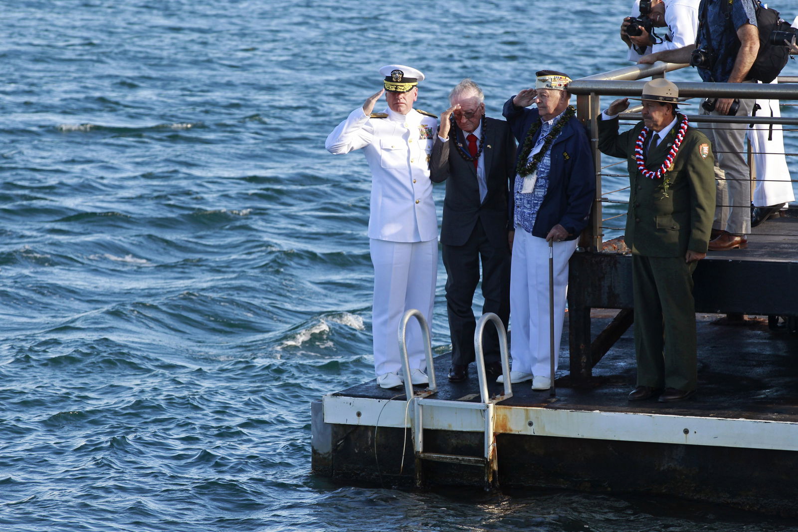 USS Arizona survivors Donald Stratton (2nd L) and Louis Conter (3rd L) salute after toasting their former shipmates, during a private reunion event at the World War Two Valor in the Pacific National Monument at Pearl Harbor in Honolulu, Hawaii December 7, 2014. 